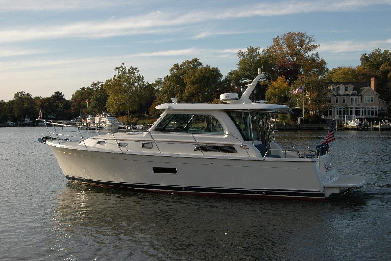 2019 Sabre 38 Salon Express yacht cruising on a serene river with lush greenery.