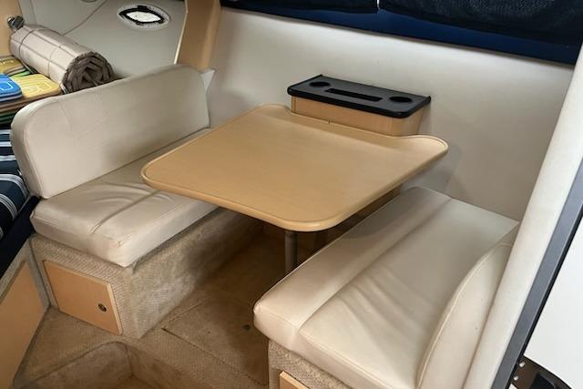 Interior of 2012 Bayliner 285 Cruiser with cozy seating and table setup.