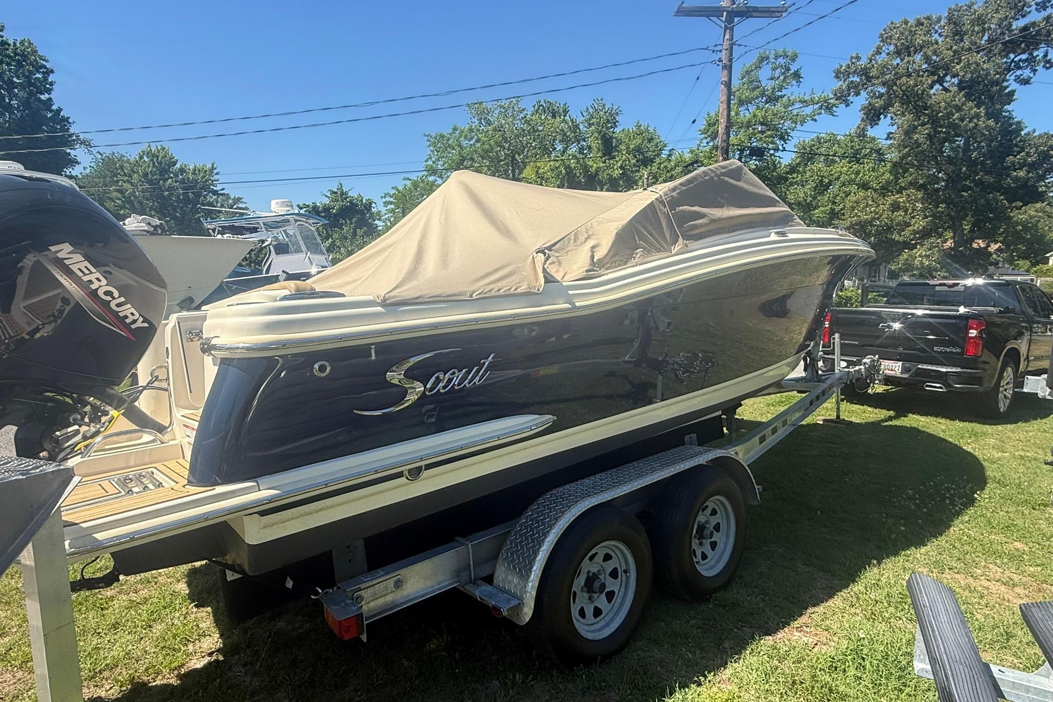 2021 Scout 215 Dorado boat on trailer with cover, parked outdoors.