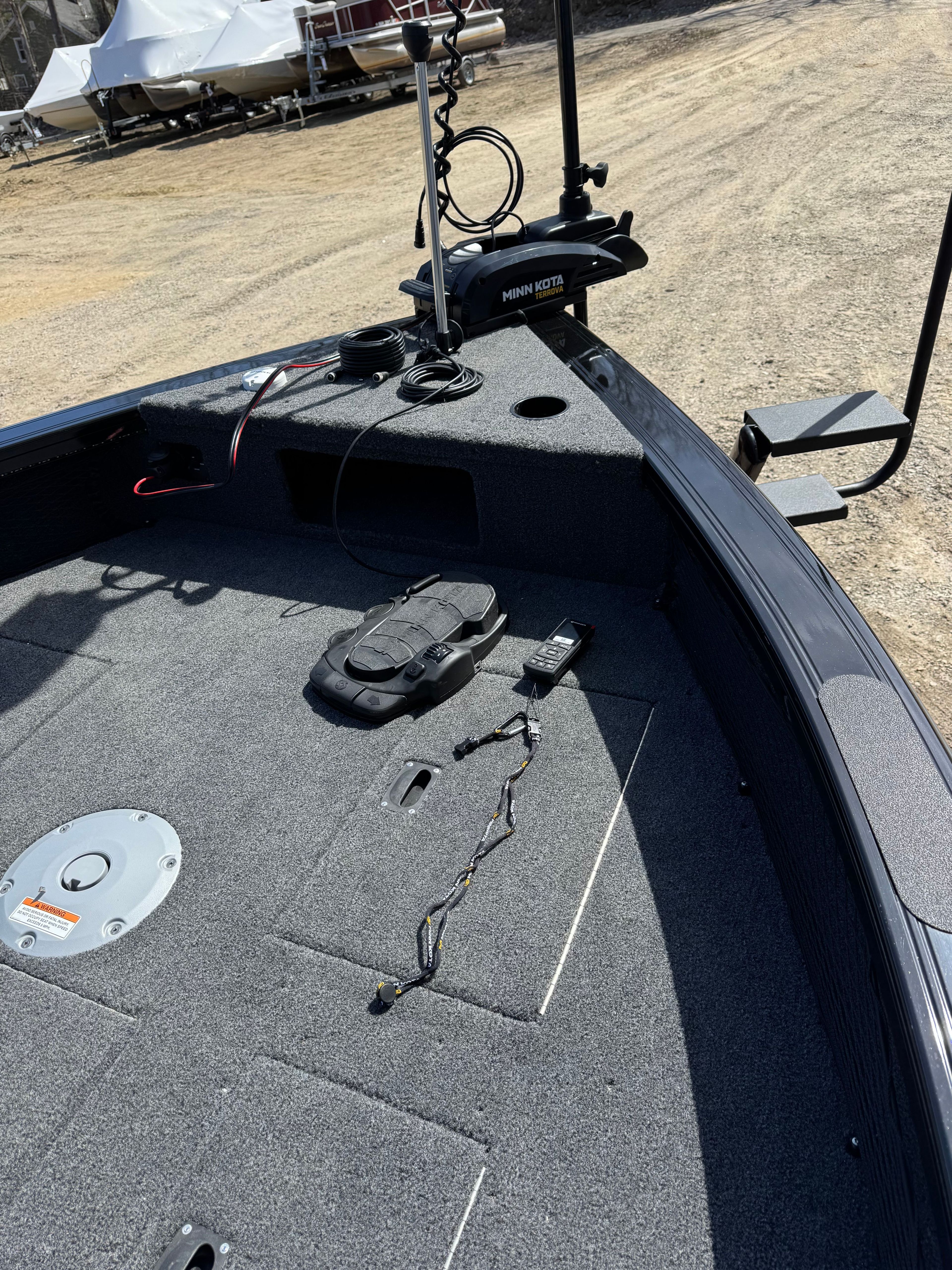 The boat has a gray carpeted deck and is equipped with fishing gear.