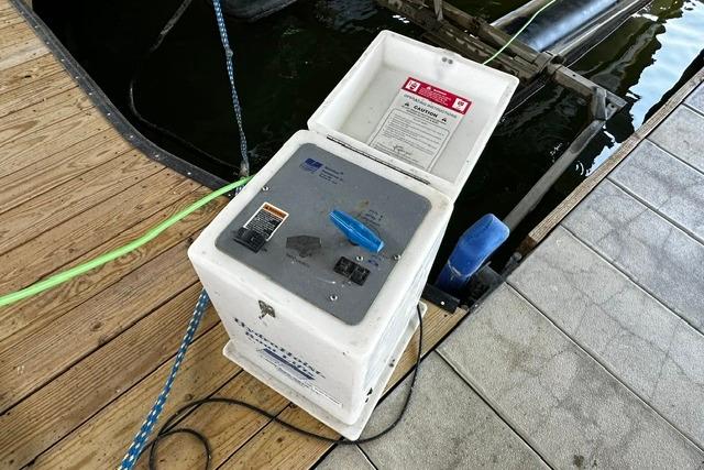 Power pedestal on dock near water, connected to a Four Winns 200 Horizon boat.