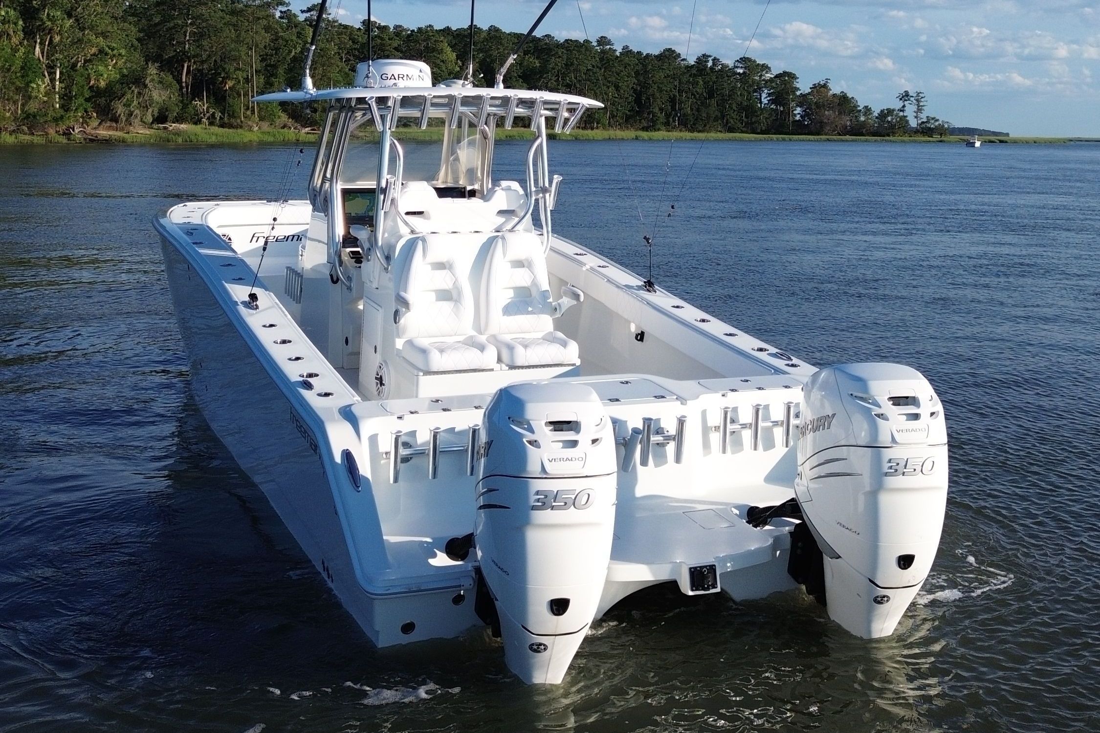 A 2018 Freeman 34VH boat with twin outboard engines on calm water.