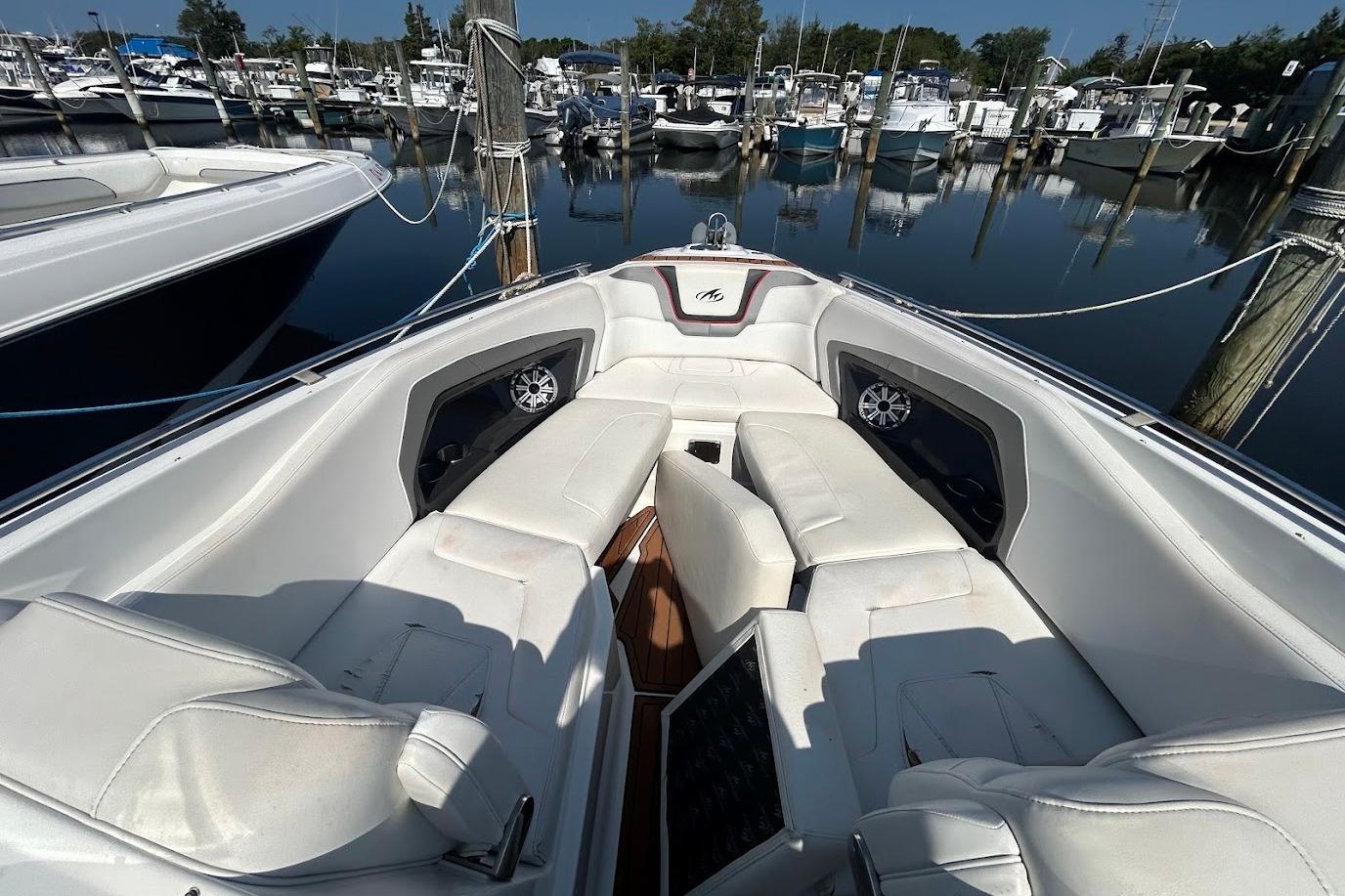 2015 Monterey 288 Super Sport boat interior with white seating at a marina.