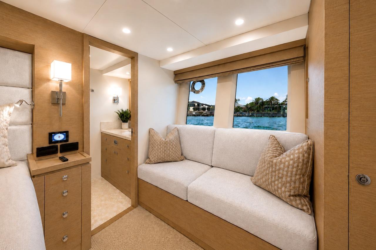 Luxurious interior of 2027 Offshore Yachts 70 CE, featuring elegant seating and scenic window view.