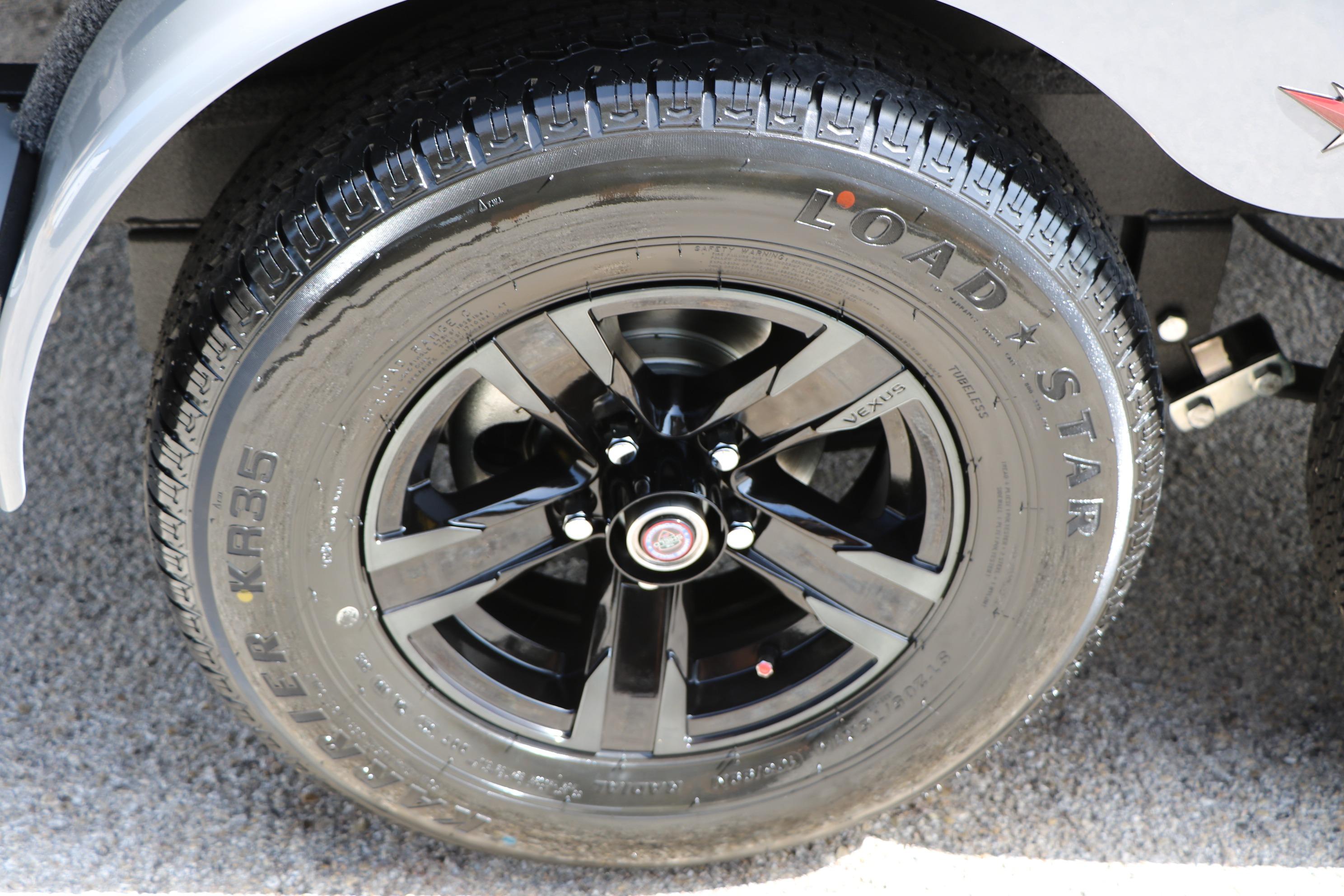 2026 Vexus AVX1980 black alloy wheel with Load Star tire on gravel surface.