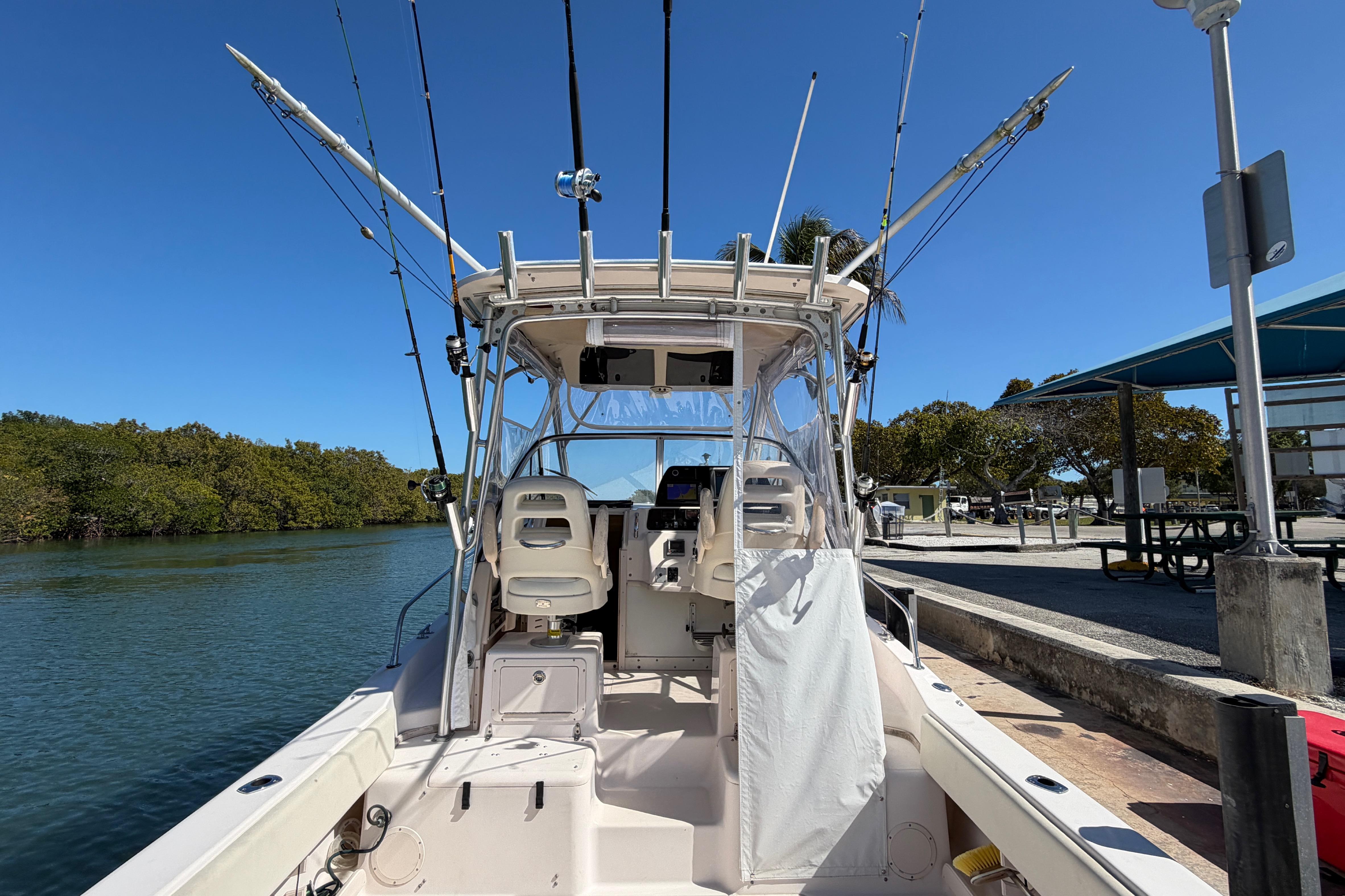 2006 Grady-White Sailfish 282 boat docked, equipped with fishing rods under clear blue sky.