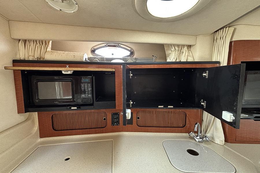 Interior of 2002 Sea Ray Sundancer 320 with microwave and storage cabinets.