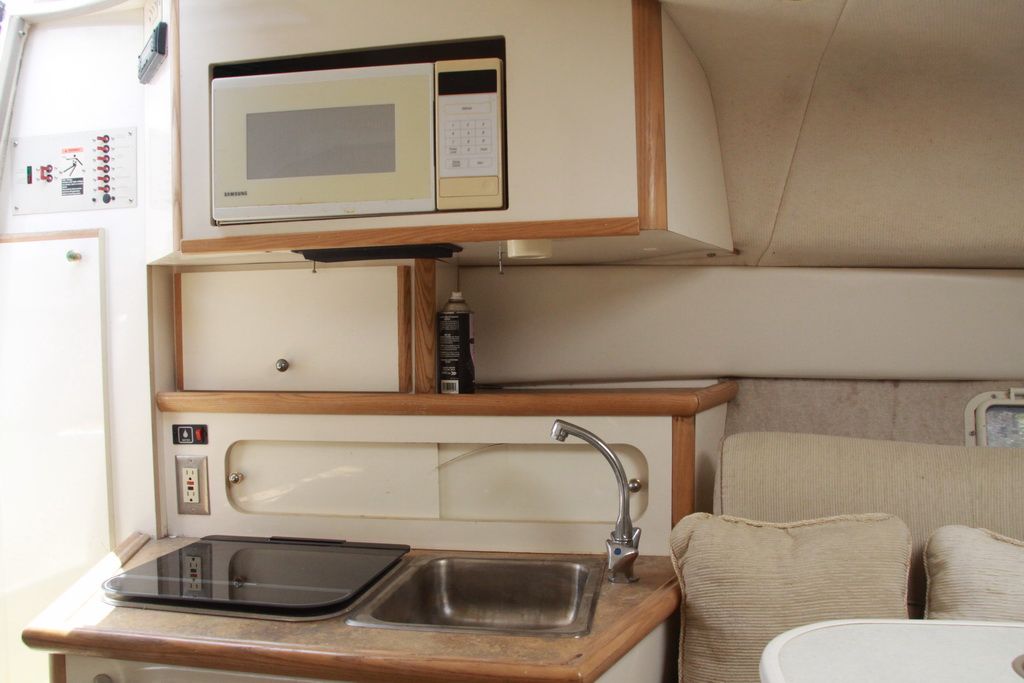 Interior of 1999 Maxum 2400 Mercruiser with kitchenette and microwave.