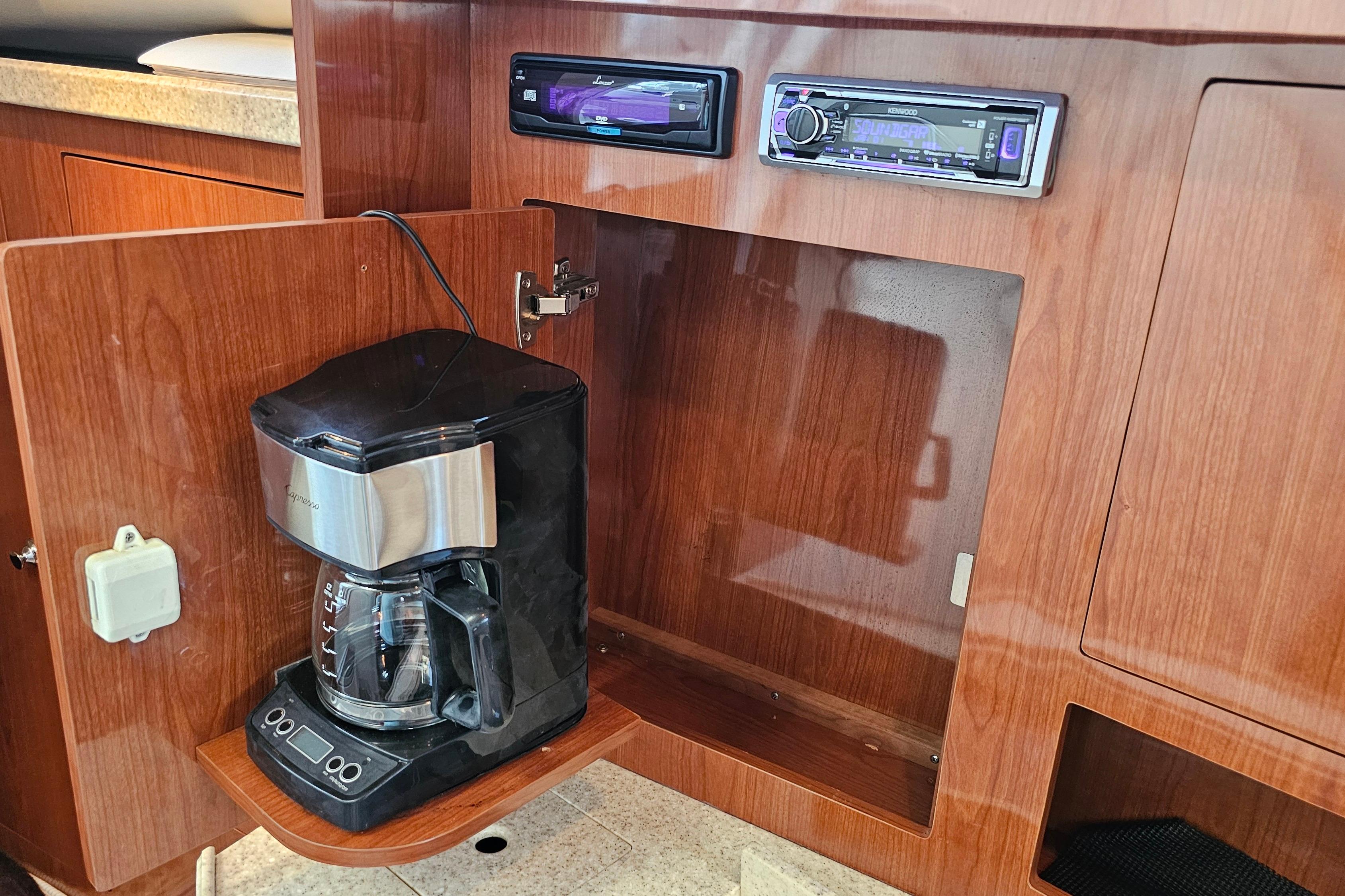 Coffee maker in a 2005 Regal 3060 Window Express yacht's wooden cabinet.