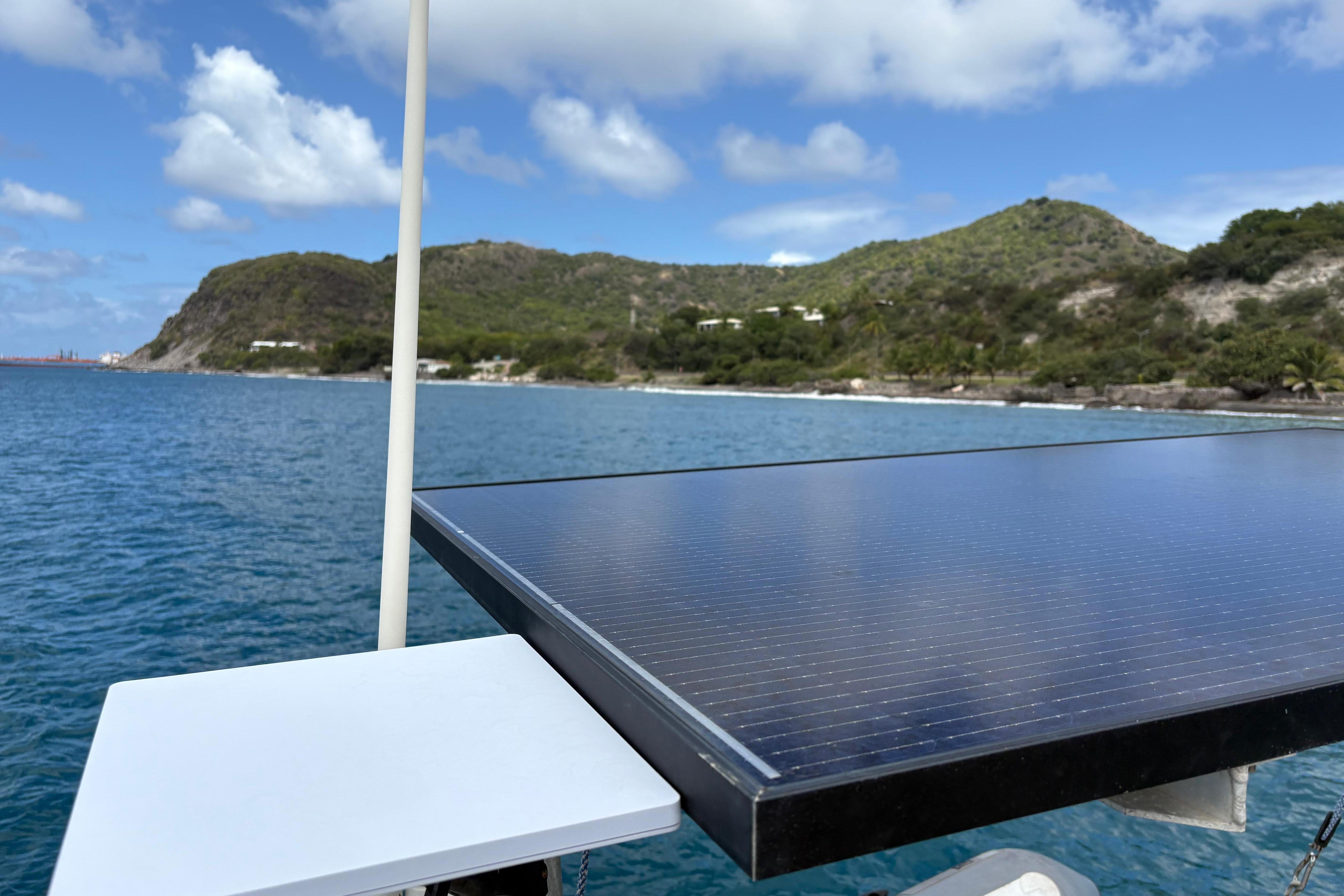 Solar panel on a 1998 Dufour 35 Classic yacht with scenic coastal backdrop.
