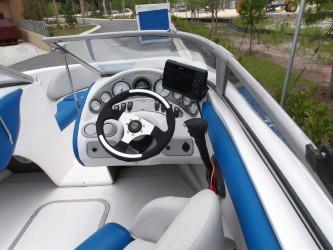 2004 Mariah SK-10 boat cockpit with steering wheel and blue-white seating.