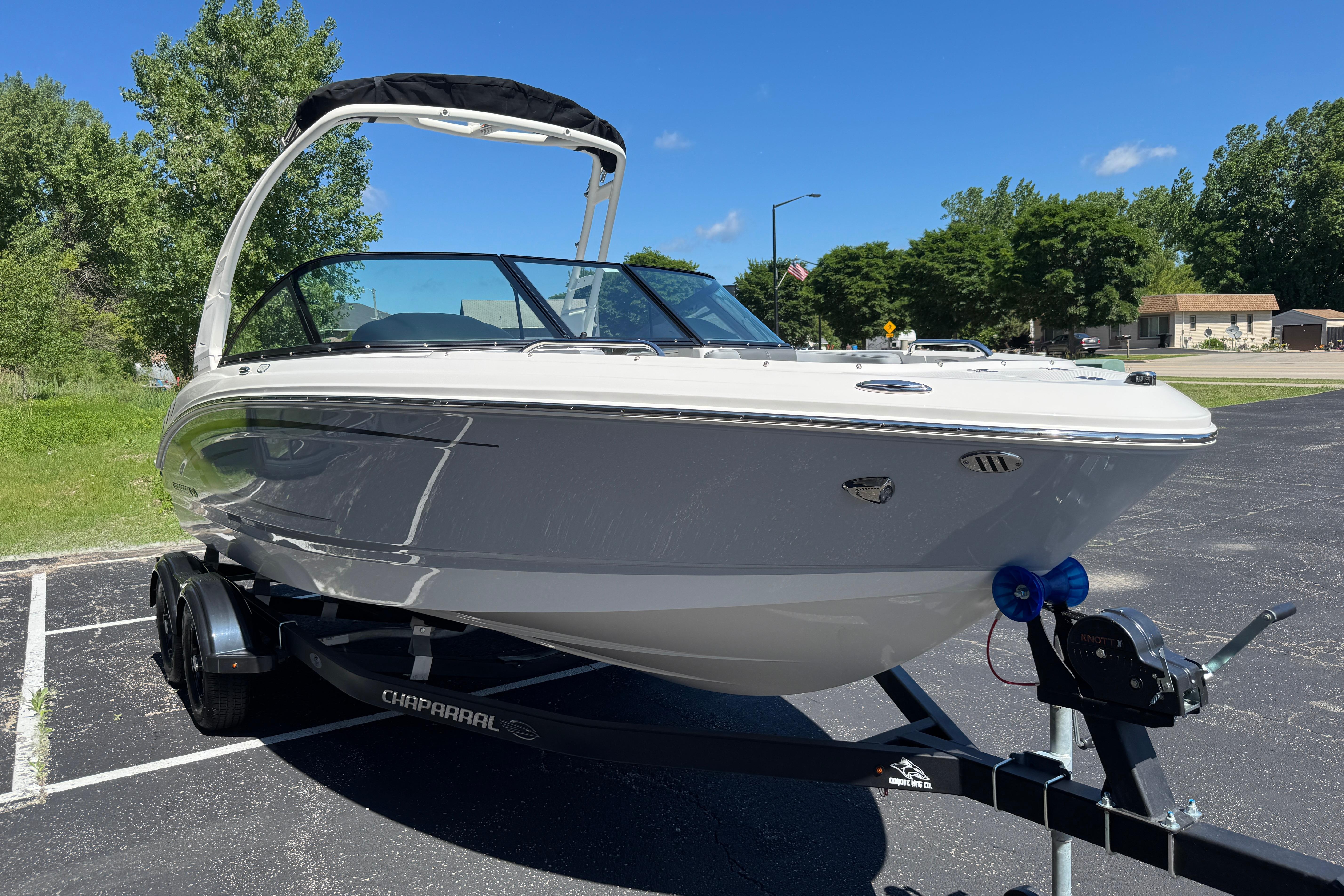 2026 Chaparral 21 SSi boat on trailer, parked outdoors on a sunny day.