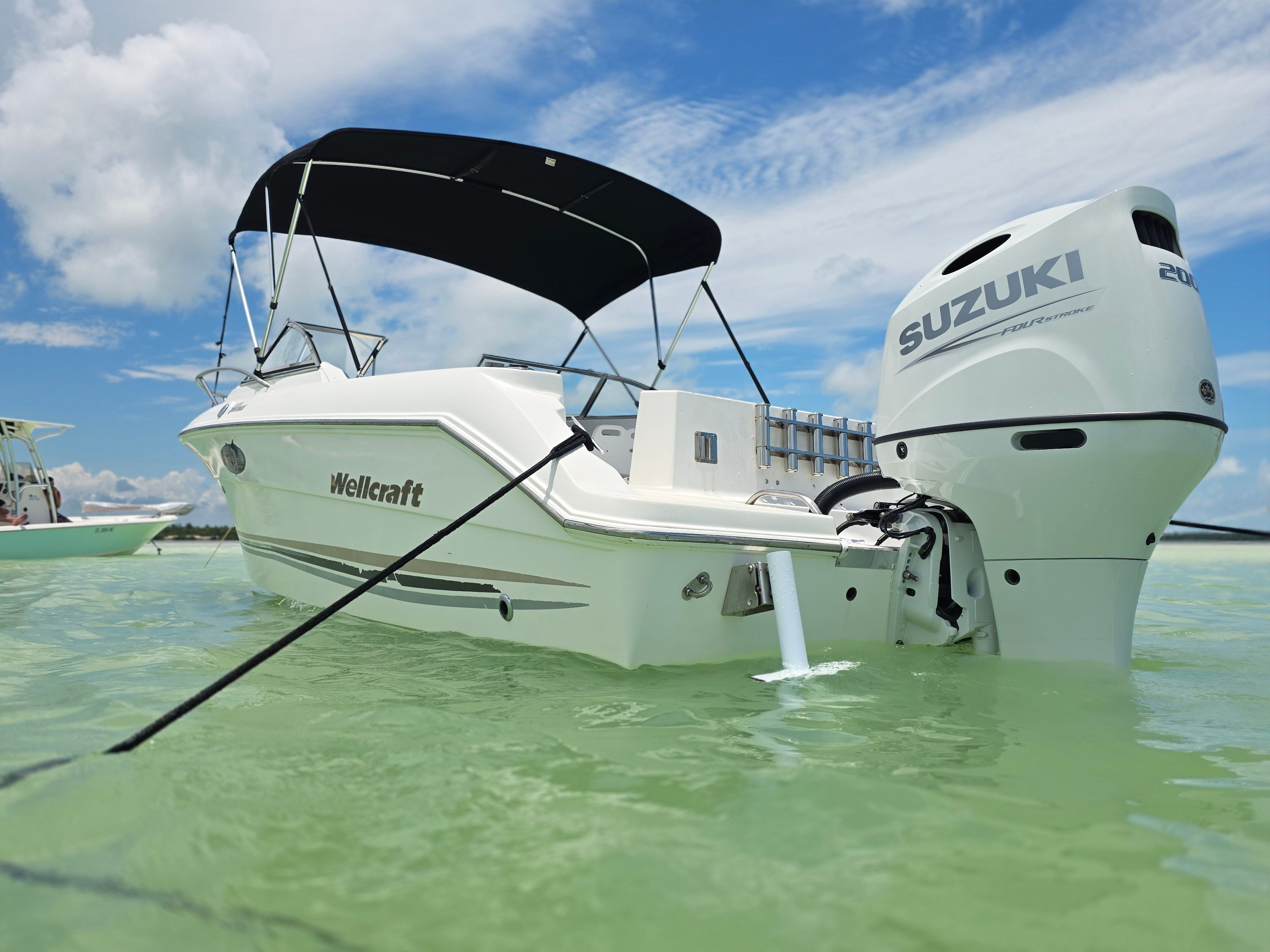 Wellcraft Sportsman 2001 boat in clear water with Suzuki engine.
