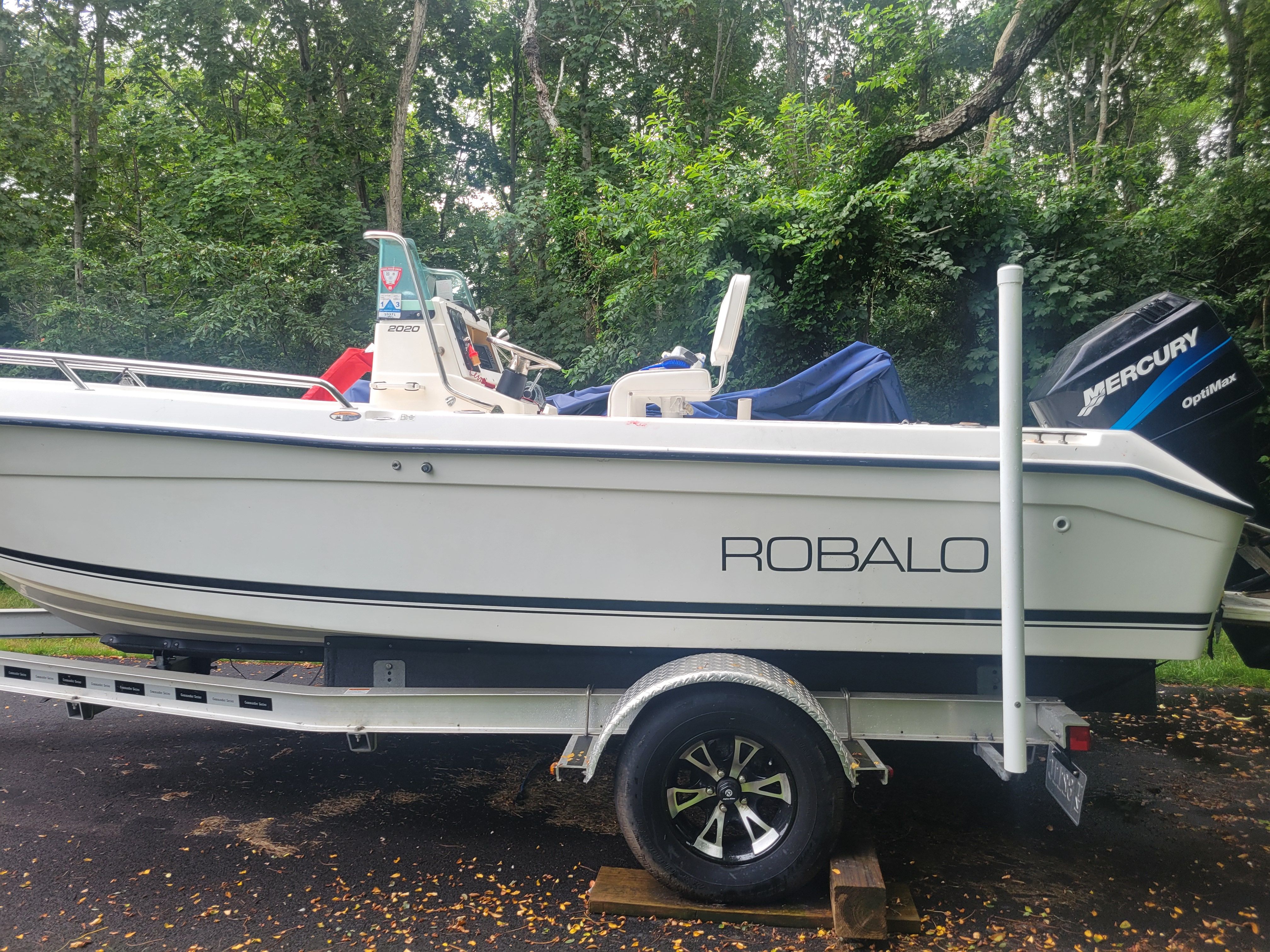Robalo 2020 Center Console boat on trailer, surrounded by lush greenery.