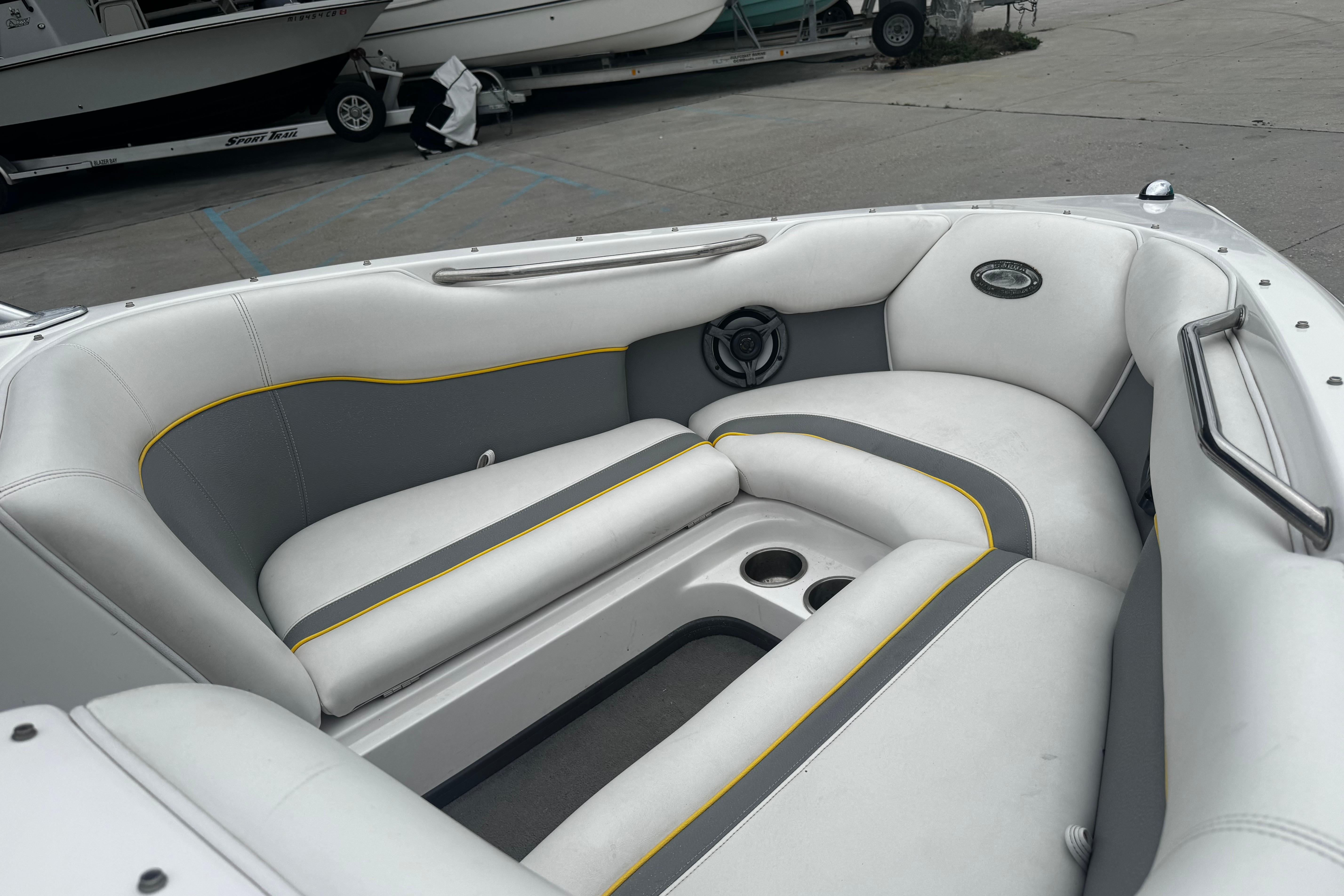 2006 Supra Launch 22 SSV boat interior with gray and white seating, cup holders, and speaker.