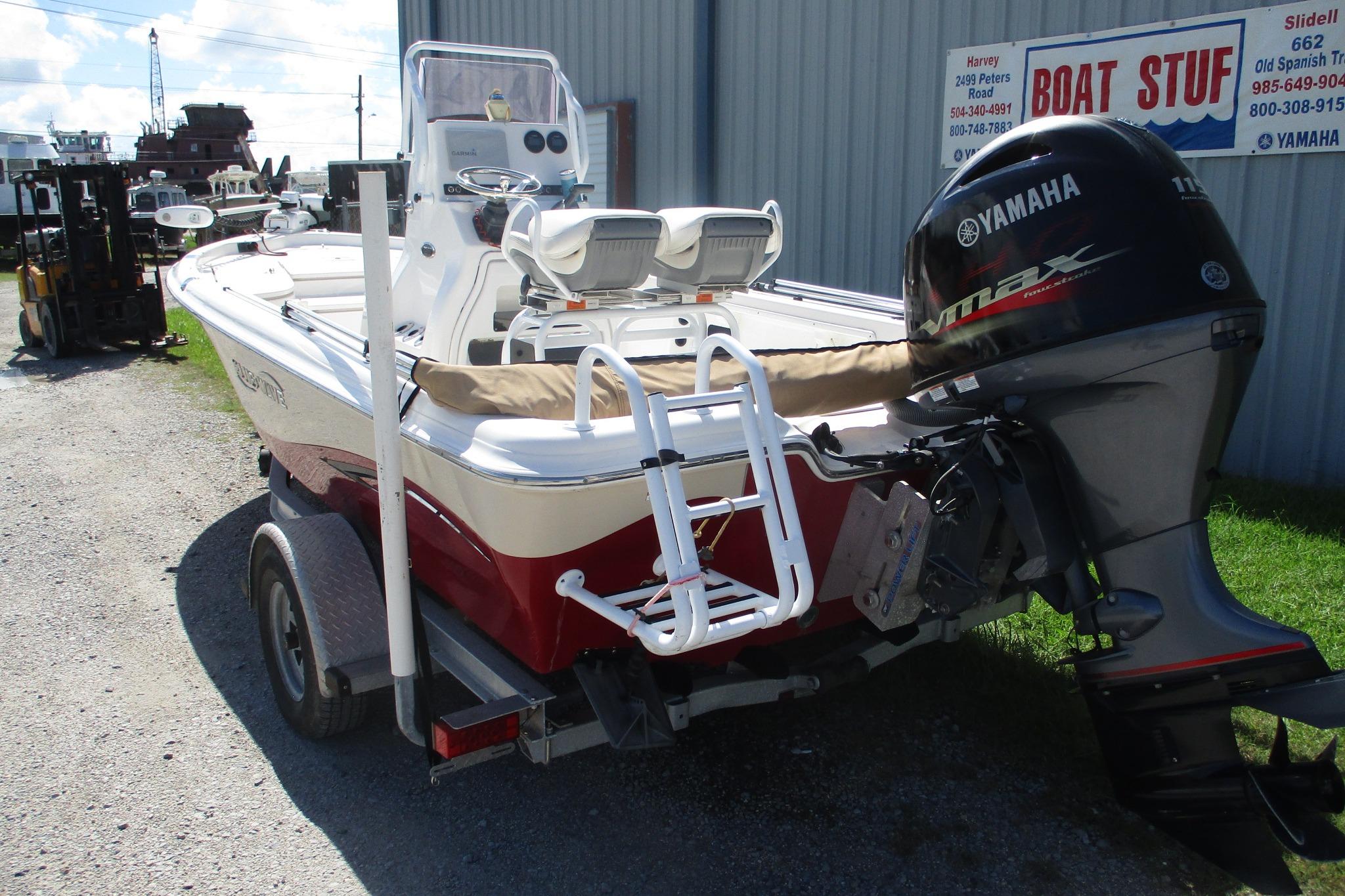 2021 Blue Wave 2000 PureBay boat with Yamaha engine on trailer, parked outside a dealership.