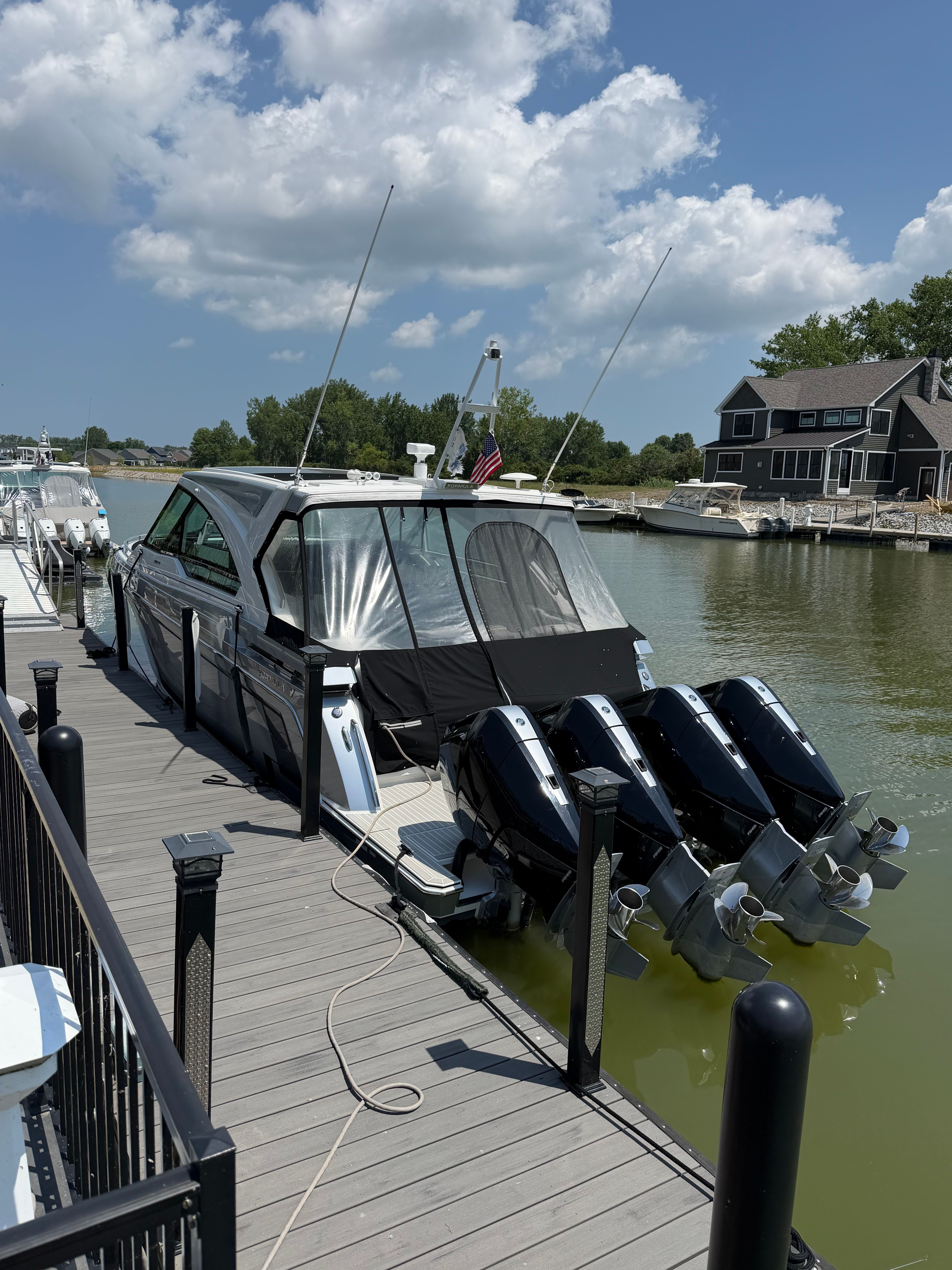A 2023 Formula 400 Super Sport Crossover docked, featuring four outboard engines.