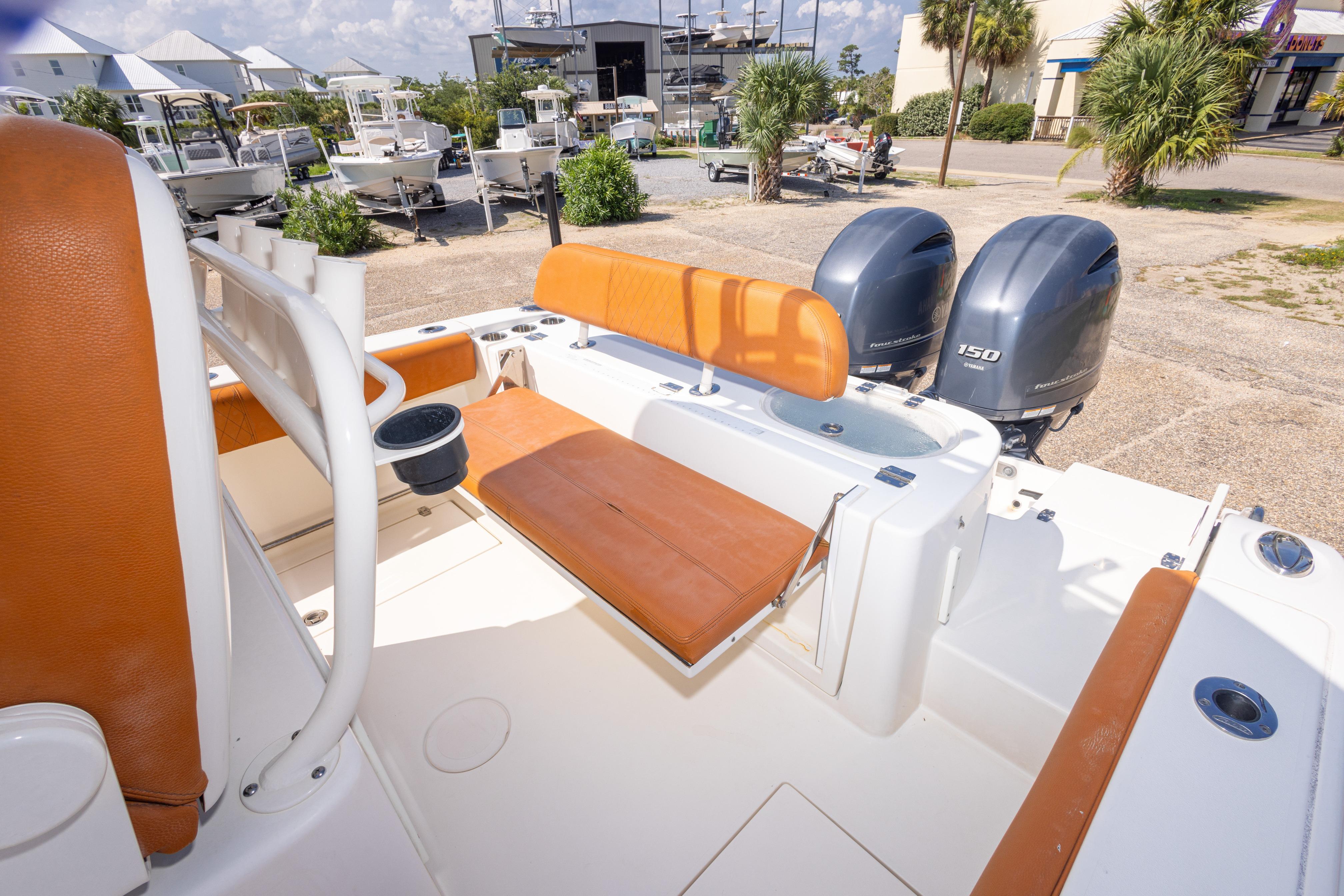 2017 Cobia 261 Center Console boat with dual engines and tan seating in a marina setting.