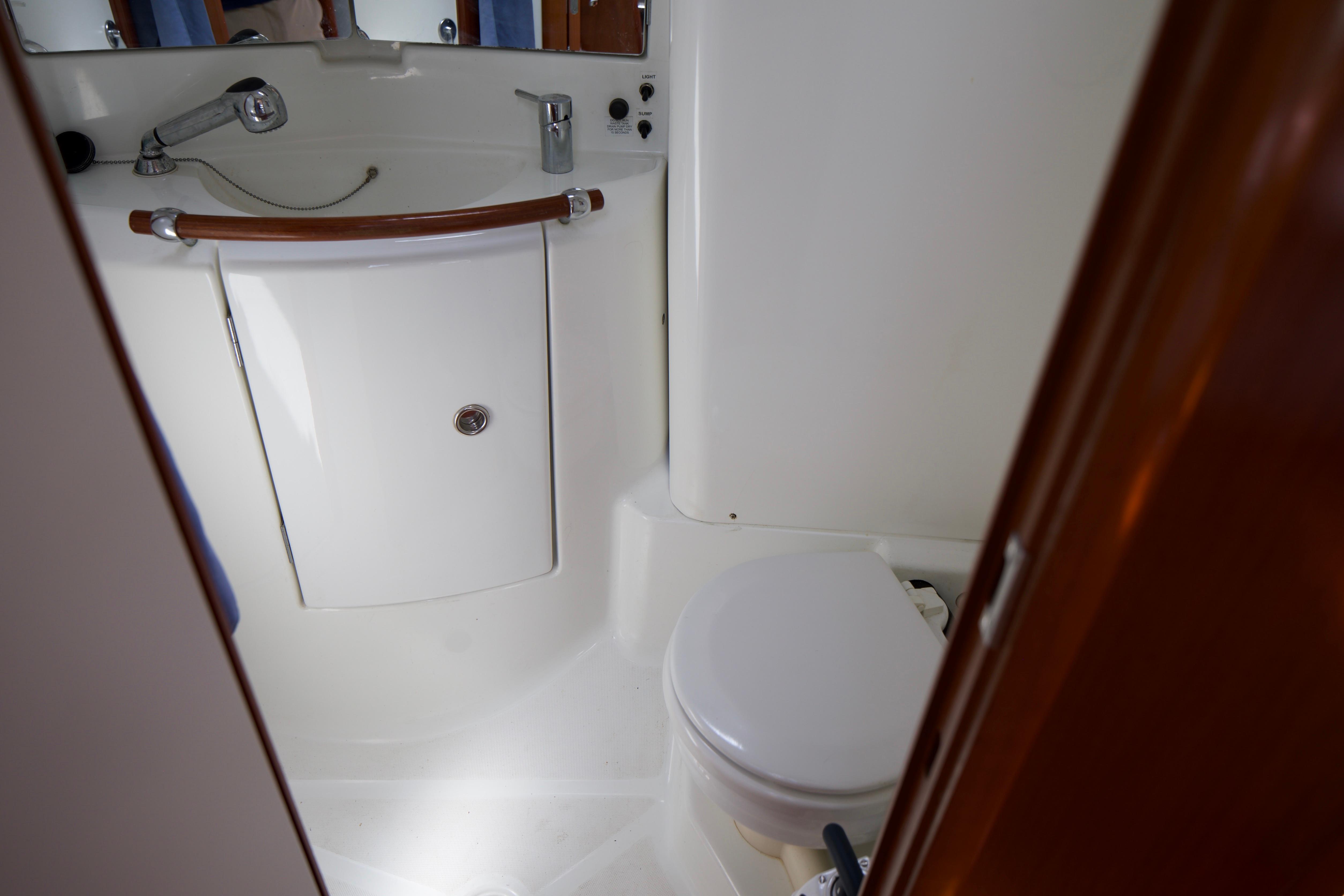Bathroom interior of a 2005 Beneteau 423 yacht, featuring a compact toilet and sink.