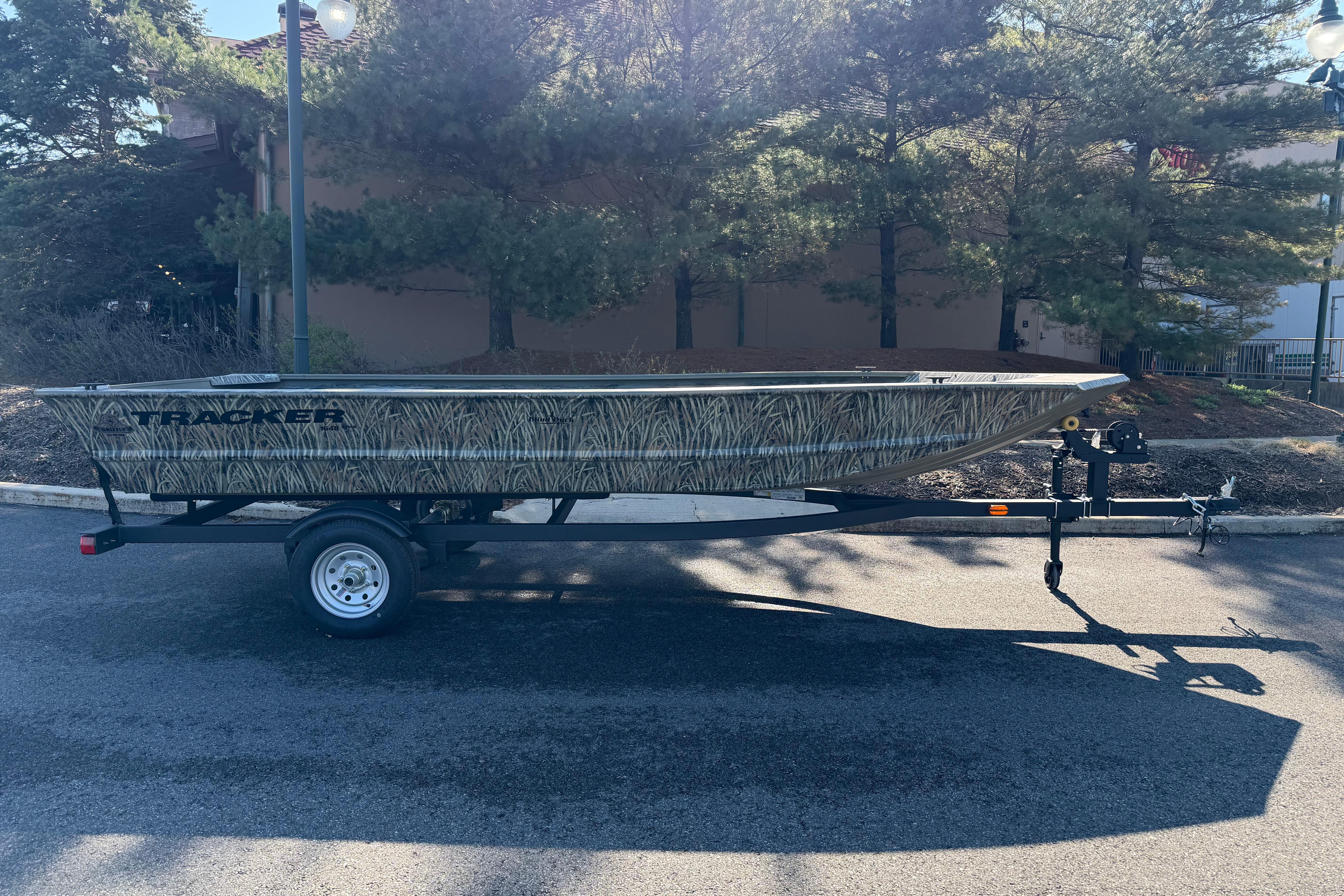 2026 Tracker Grizzly 1648 Utility boat on trailer, parked outdoors.