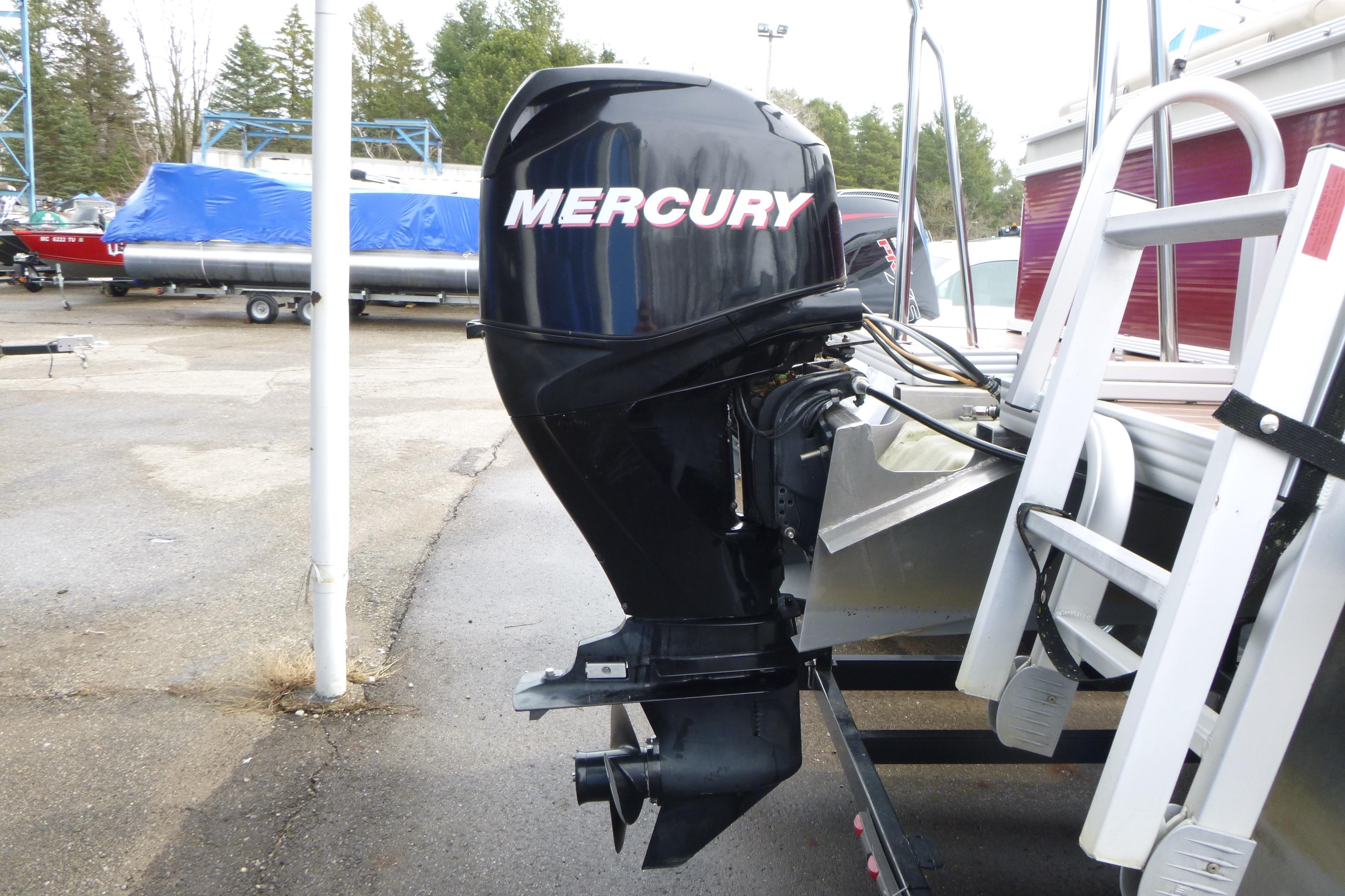 Mercury outboard motor on 2012 Crest 230SLR Classic boat, parked outdoors.