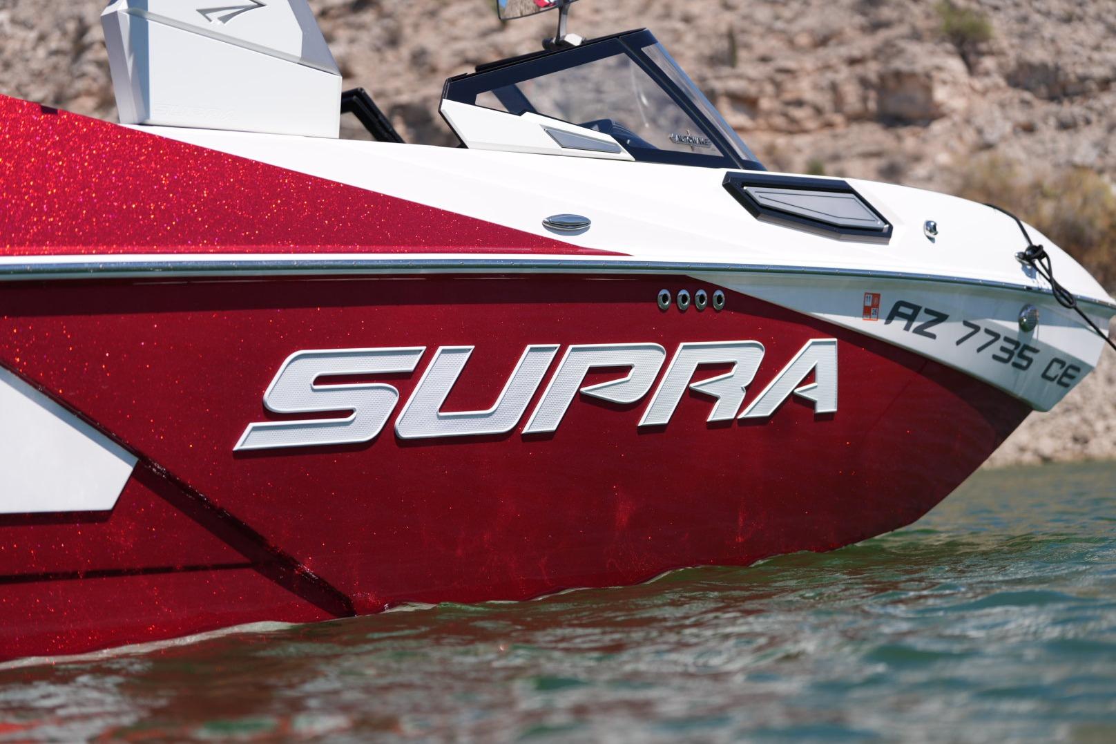 2023 Supra SE 550 boat with red and white design on water.
