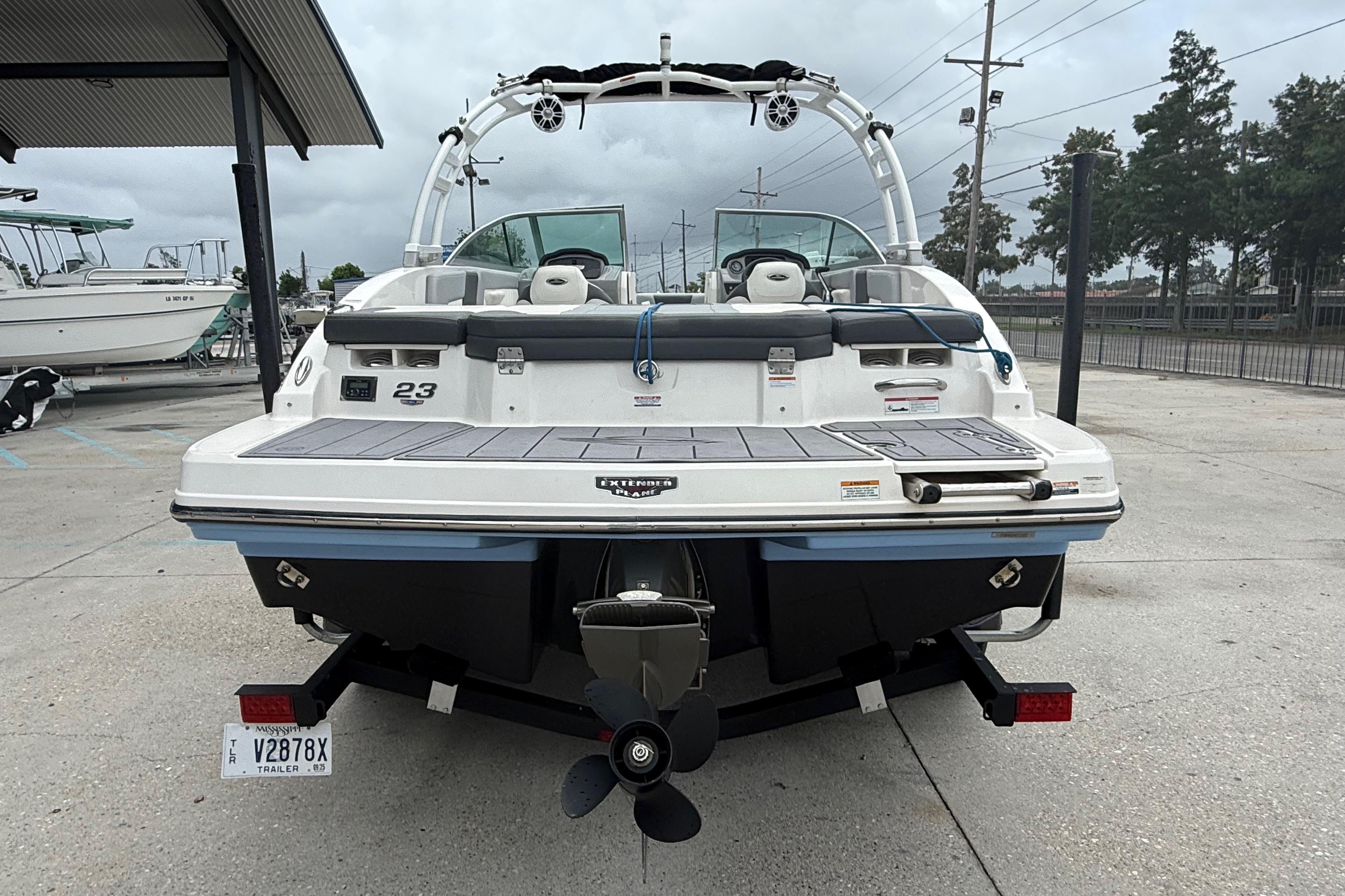 2023 Chaparral 230 SSi boat rear view, parked on a trailer in a marina.