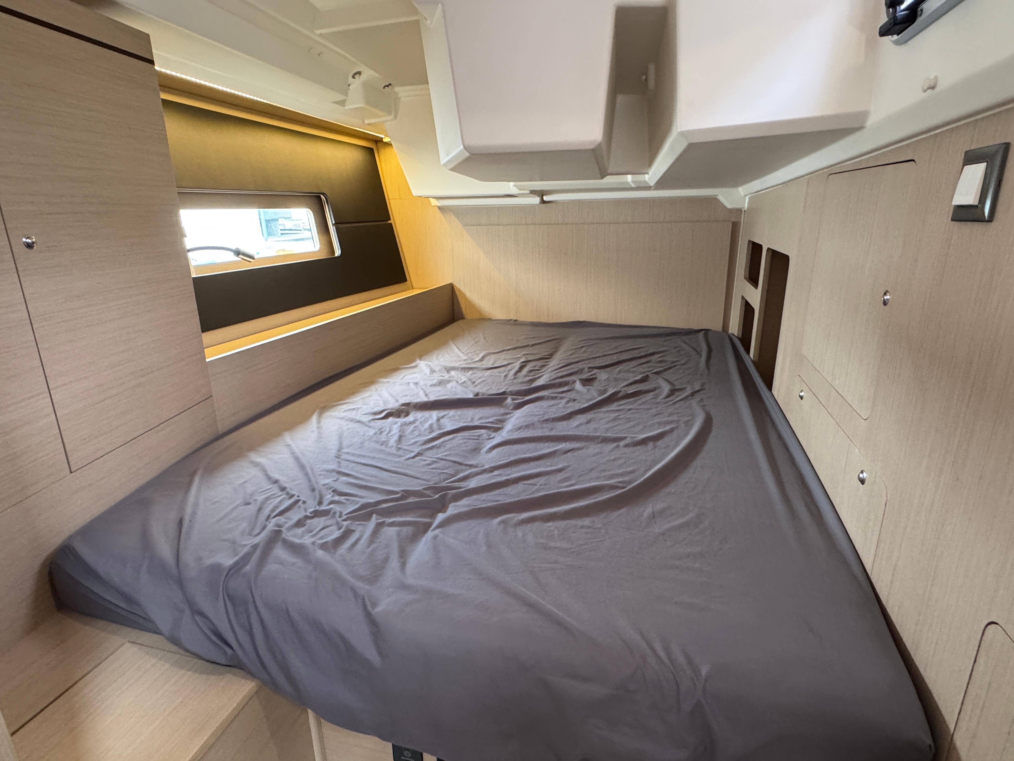 Interior cabin of 2021 Beneteau Oceanis 46.1 yacht with cozy bed and modern design.