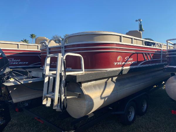 2020 Sun Tracker Party Barge 24 DLX pontoon boat on trailer, red and white design.