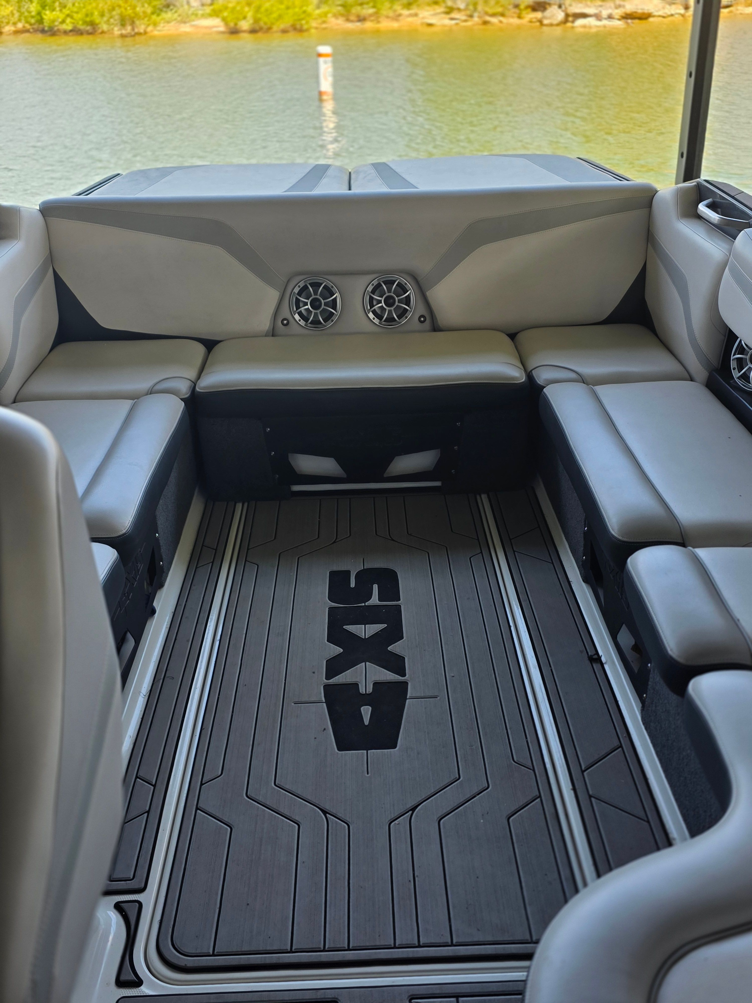 Interior of a 2017 Axis T23 boat with gray upholstery and speakers.