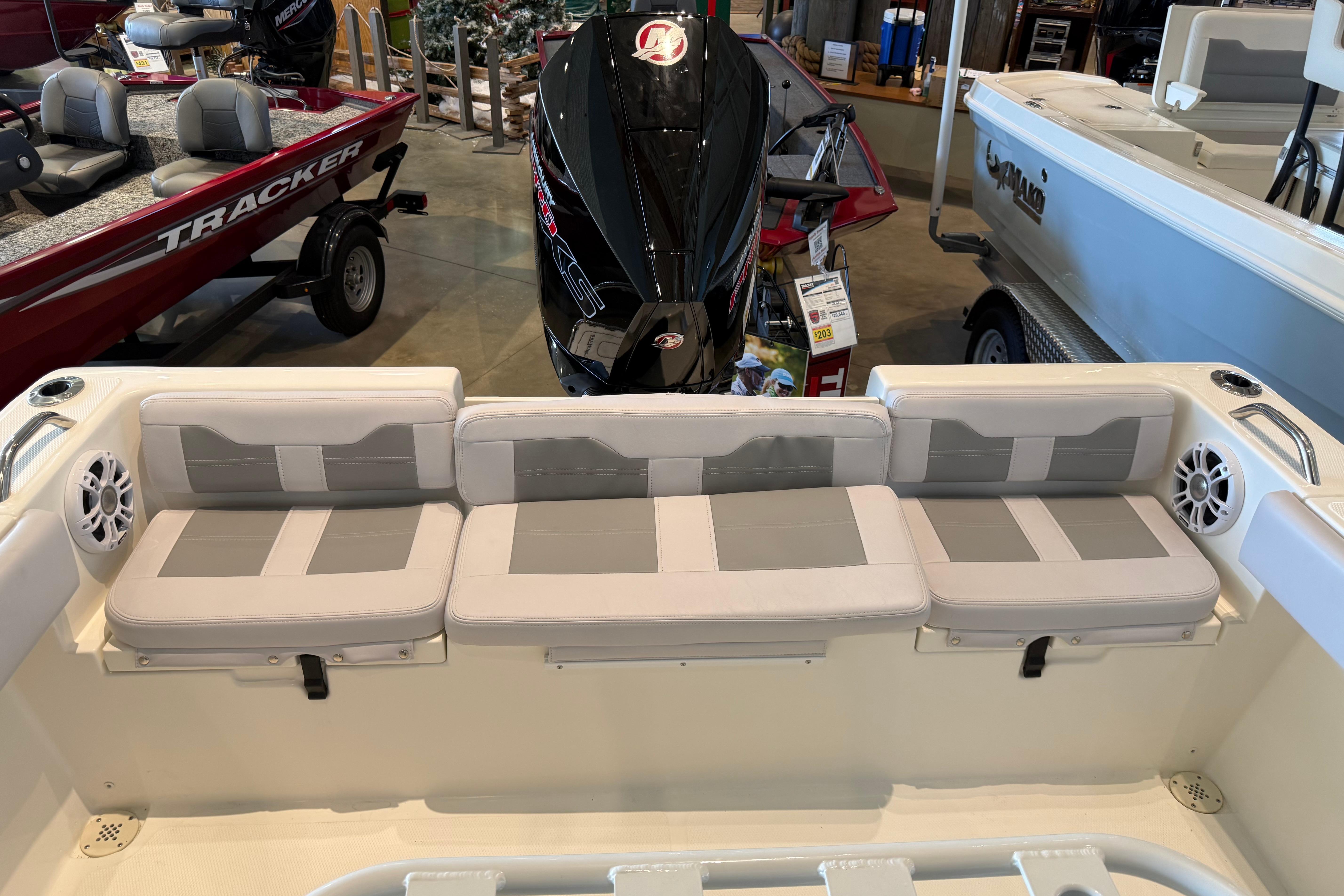 2026 Mako 214 Center Console boat interior with cushioned seating and motor display.