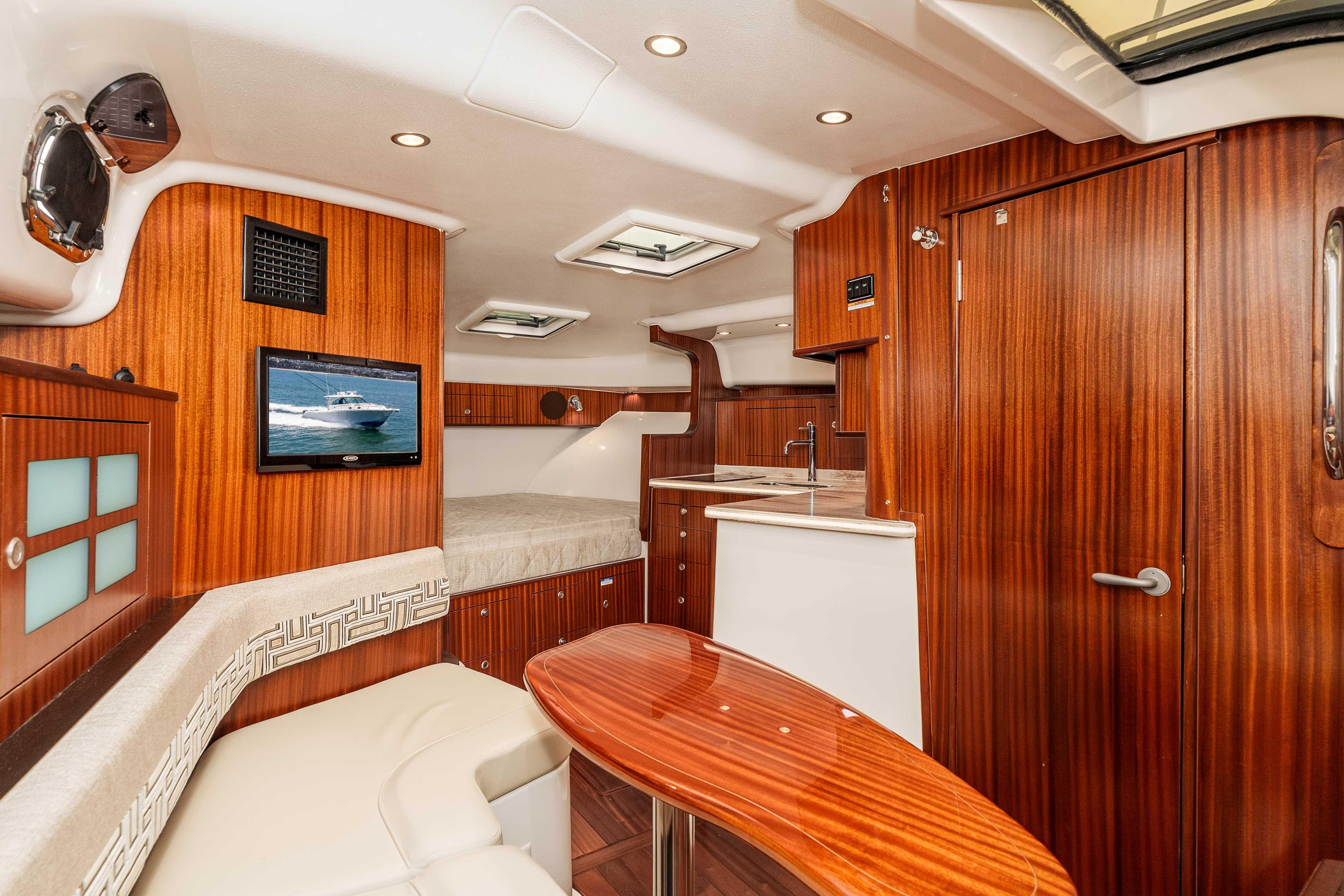 Luxurious interior of 2022 Pursuit OS 385 Offshore boat with wood finishes and modern amenities.