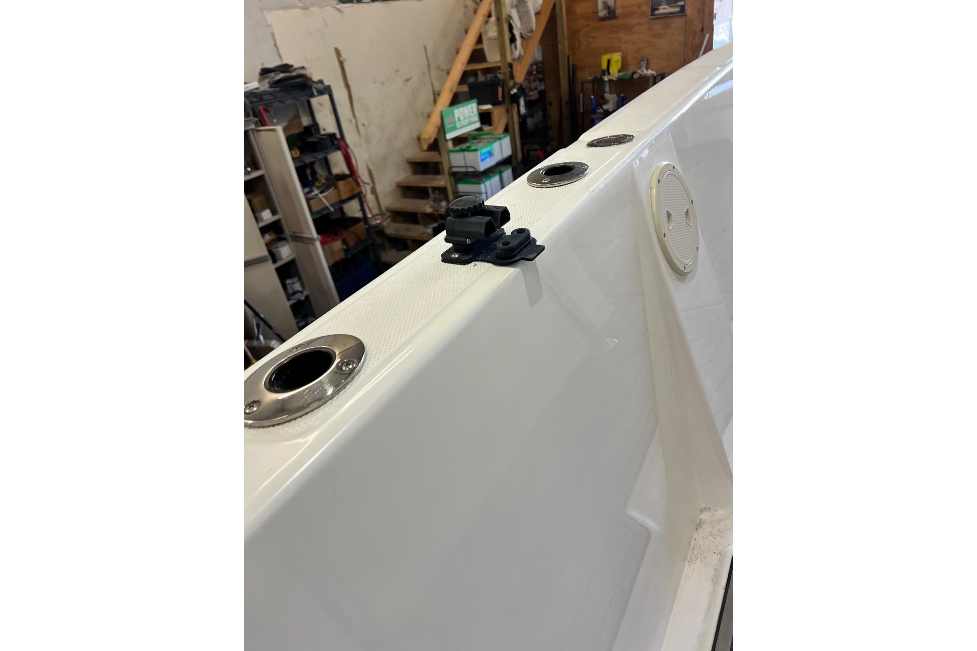 2021 Custom Infusion 34 CC boat deck with rod holders in a workshop.