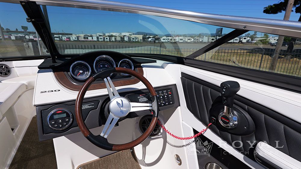 Helm of the Sea Ray SLX 230 with wood steering wheel and instruments.