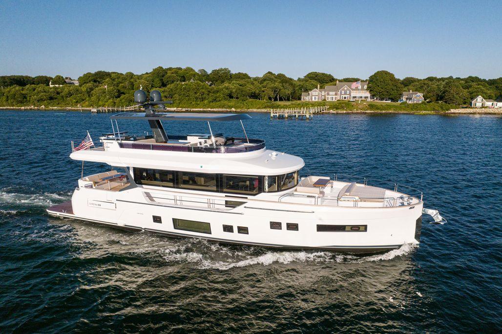 2023 Sirena 68 yacht cruising on a scenic coastal waterway.