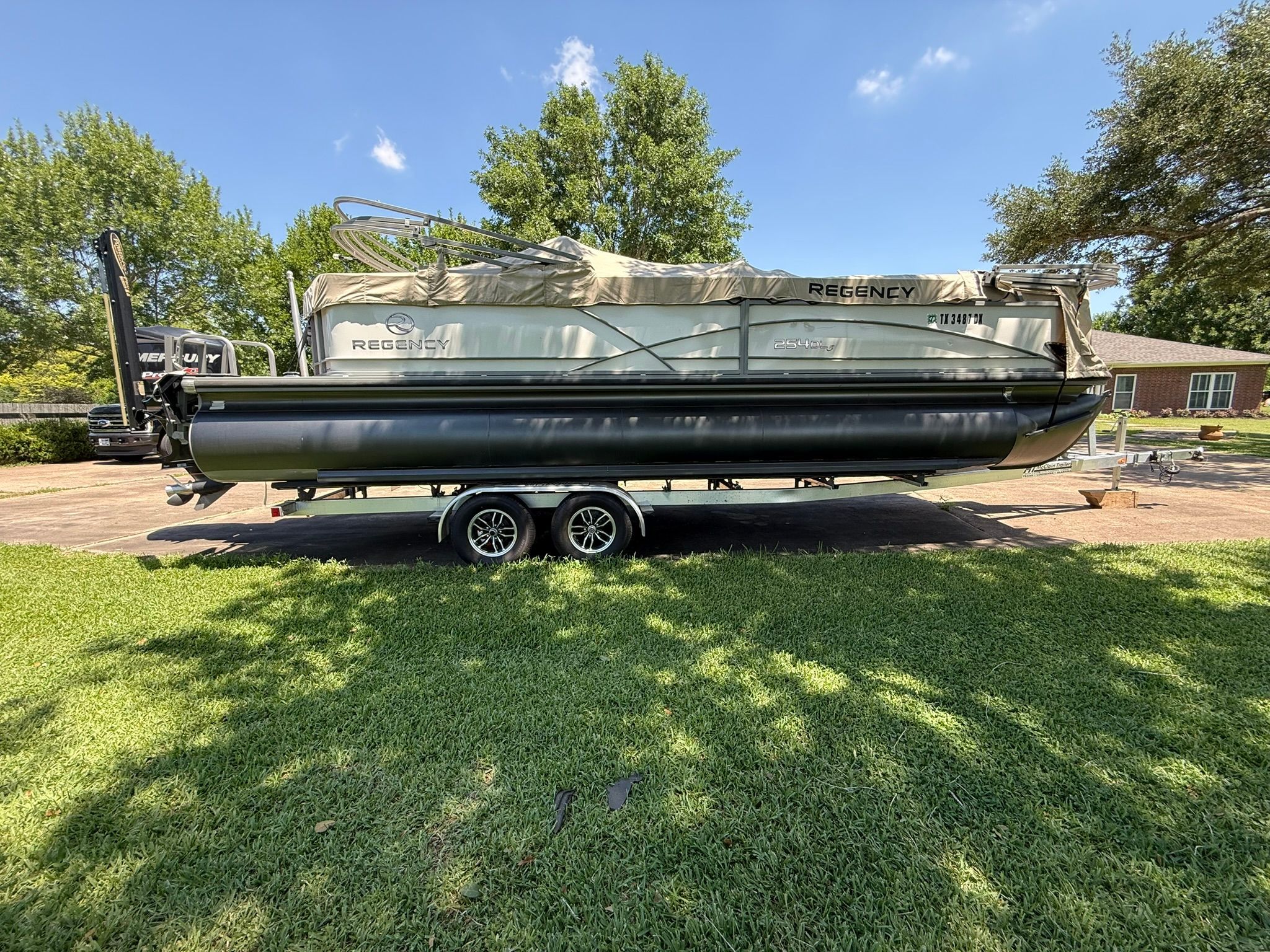 A Regency Yachts 254 Dhl3 boat on a trailer in a yard.