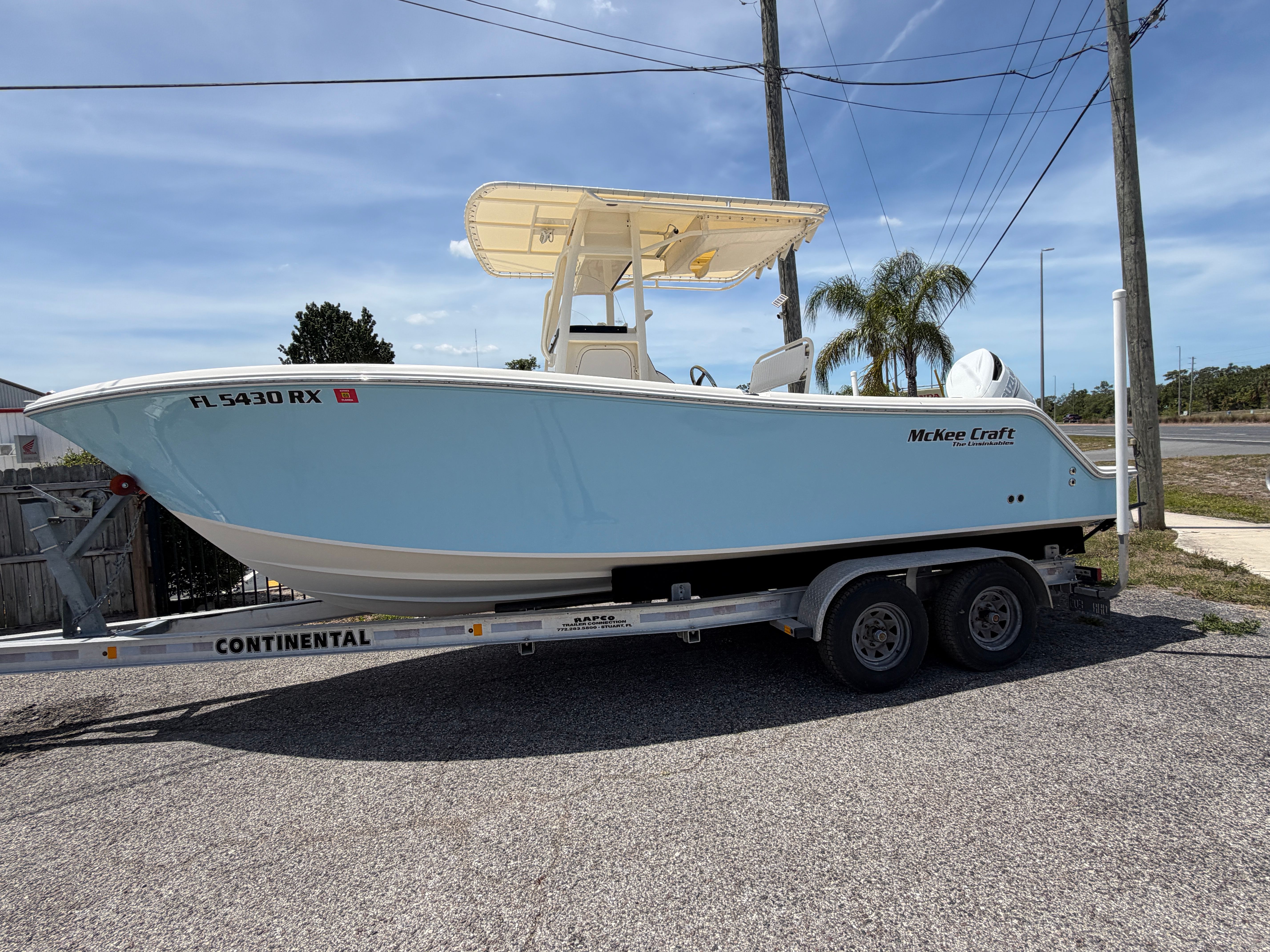 2004 McKee Craft 24 FREEDOM boat on trailer, blue sky.