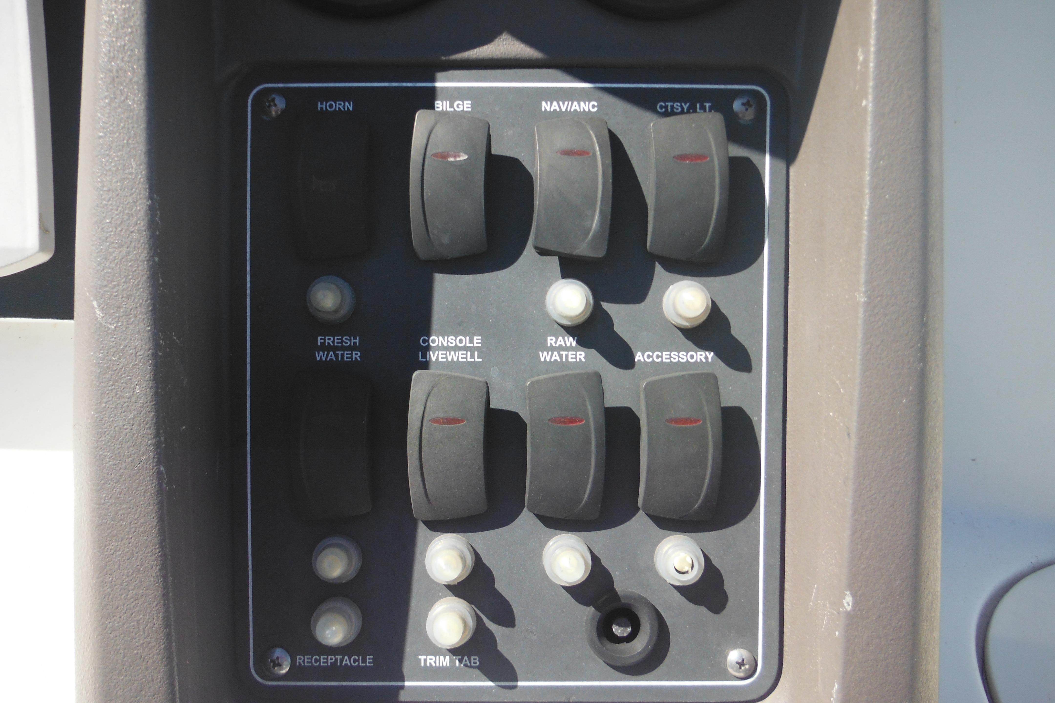Control panel of a 2009 Boston Whaler 200 Dauntless boat with labeled switches.