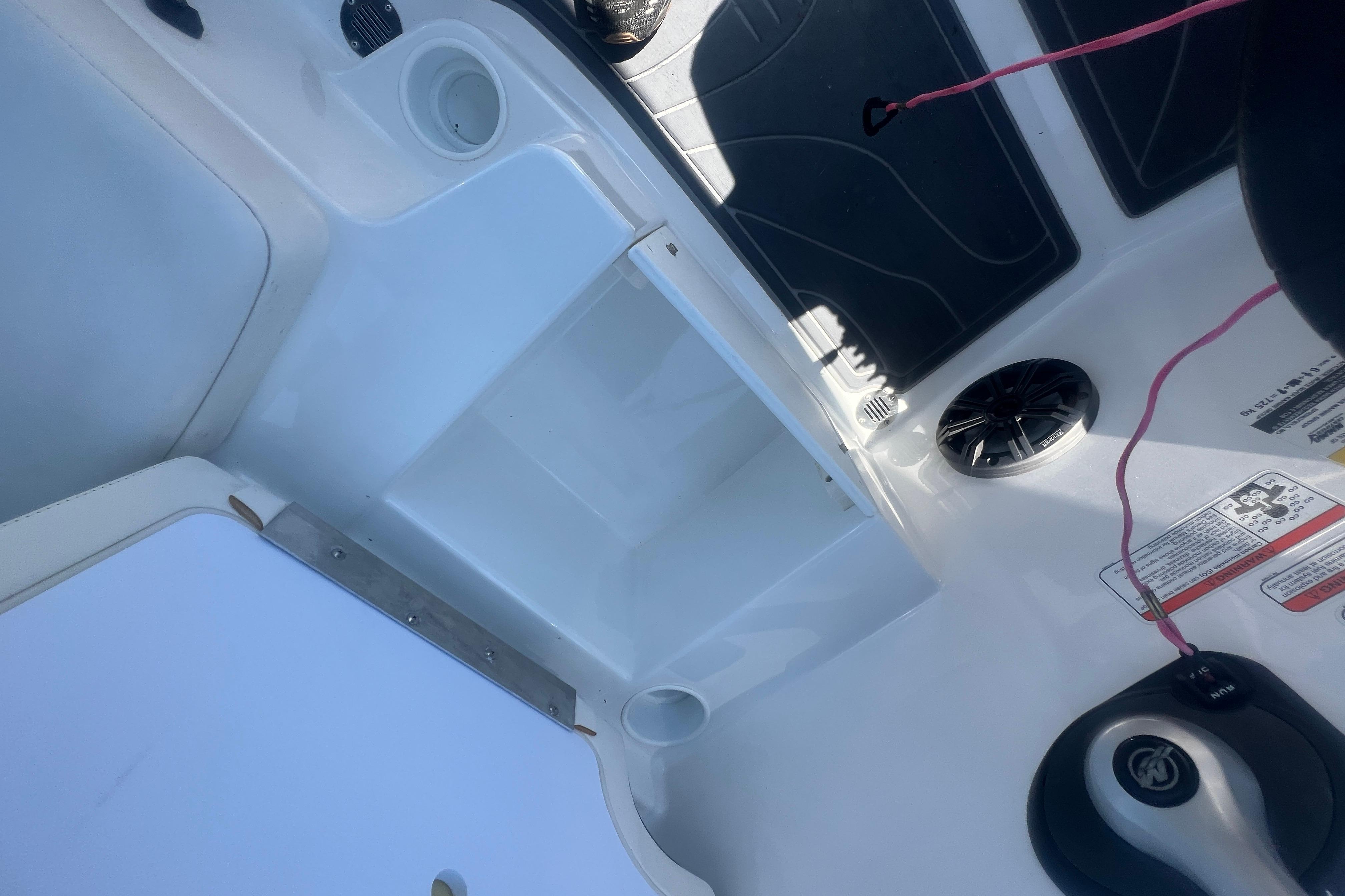 Interior of a 2023 Tahoe T16 boat featuring storage compartments and control panel.