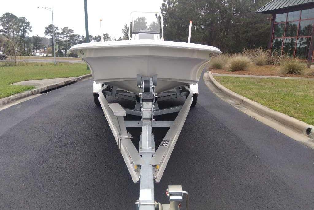 2026 Mako 18 Pro Skiff boat on trailer, parked on asphalt road.