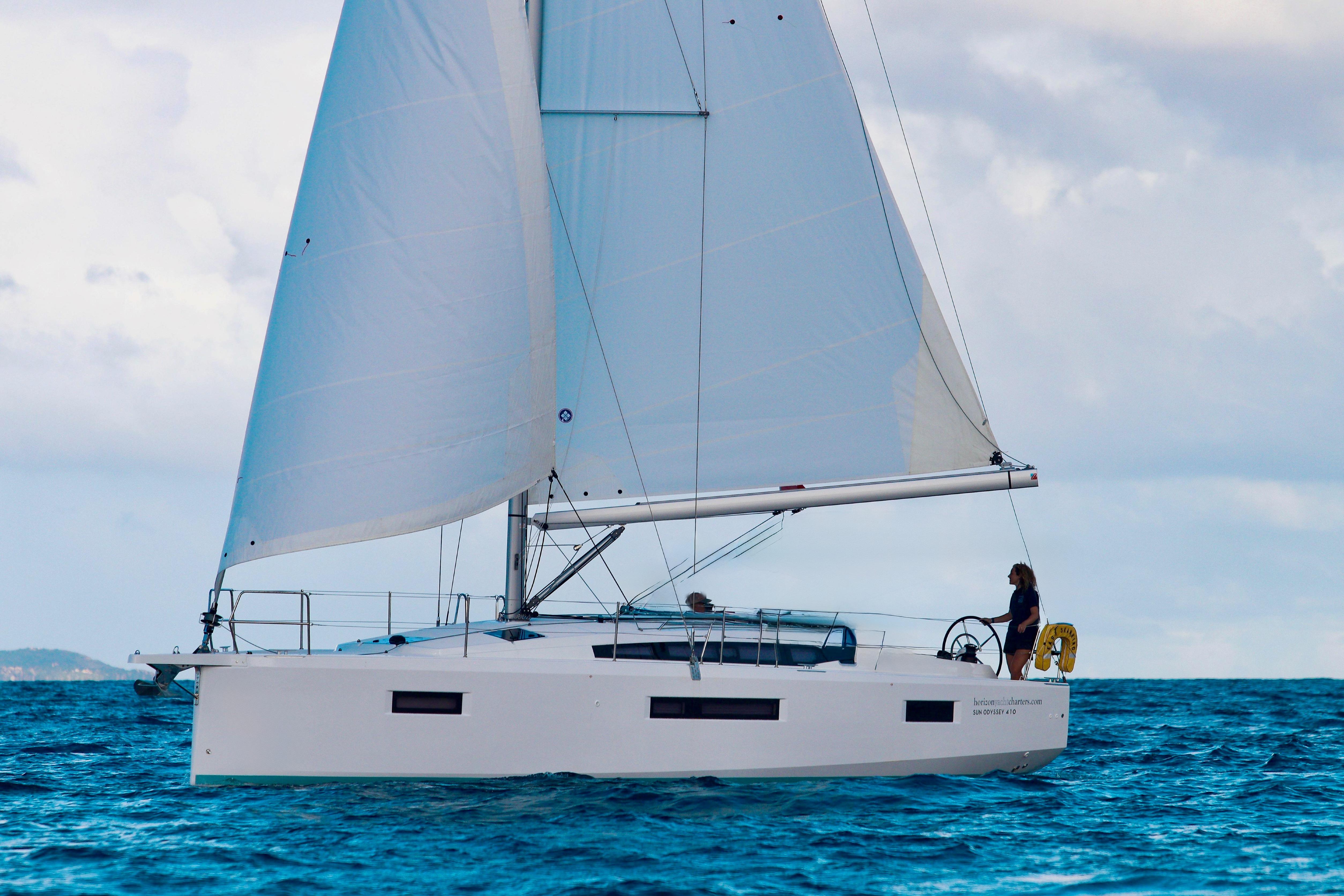 2024 Jeanneau Sun Odyssey 410 sailing on open water under clear skies.