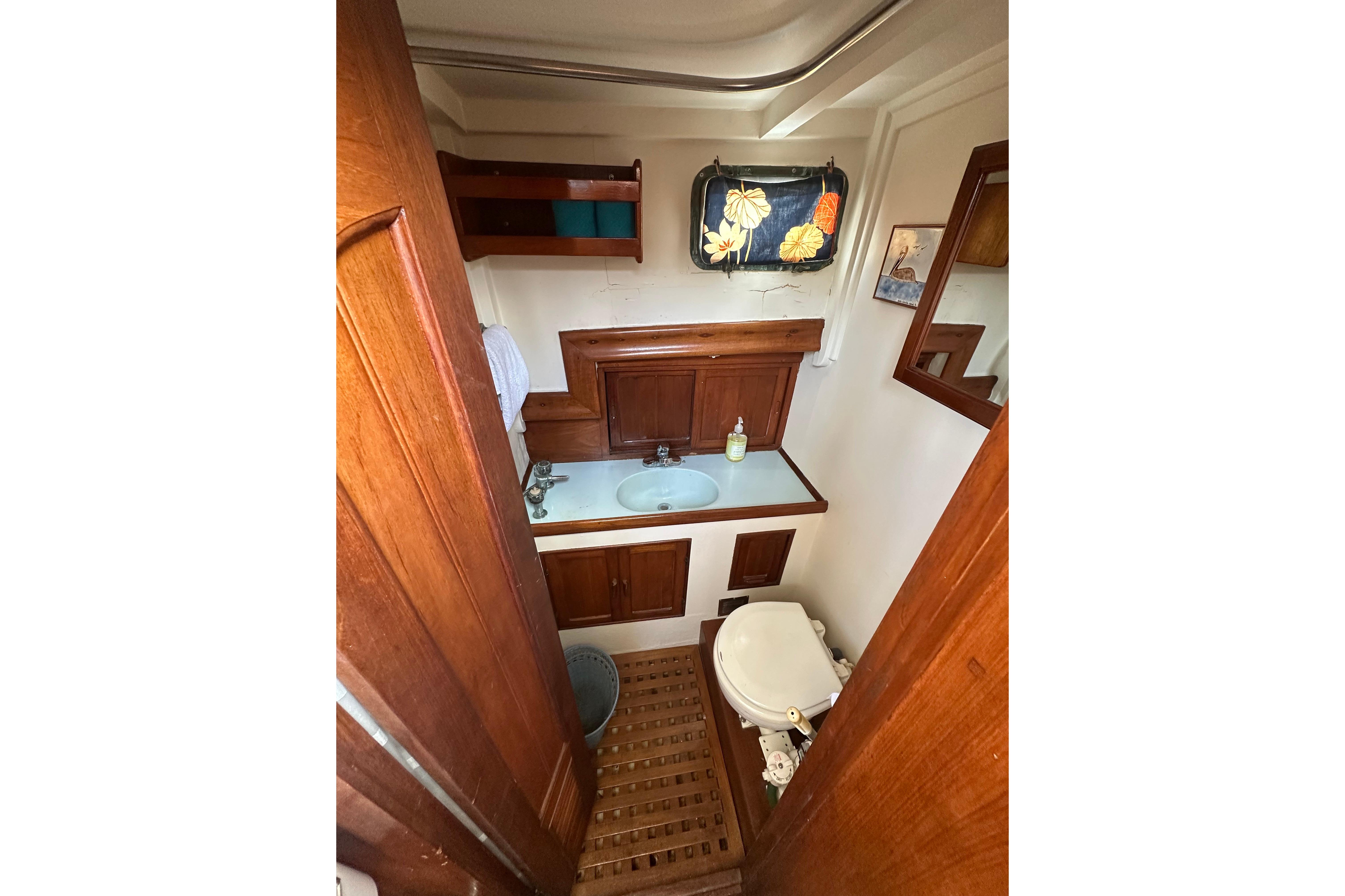1973 CHB 33 boat bathroom with wooden cabinetry and nautical decor.
