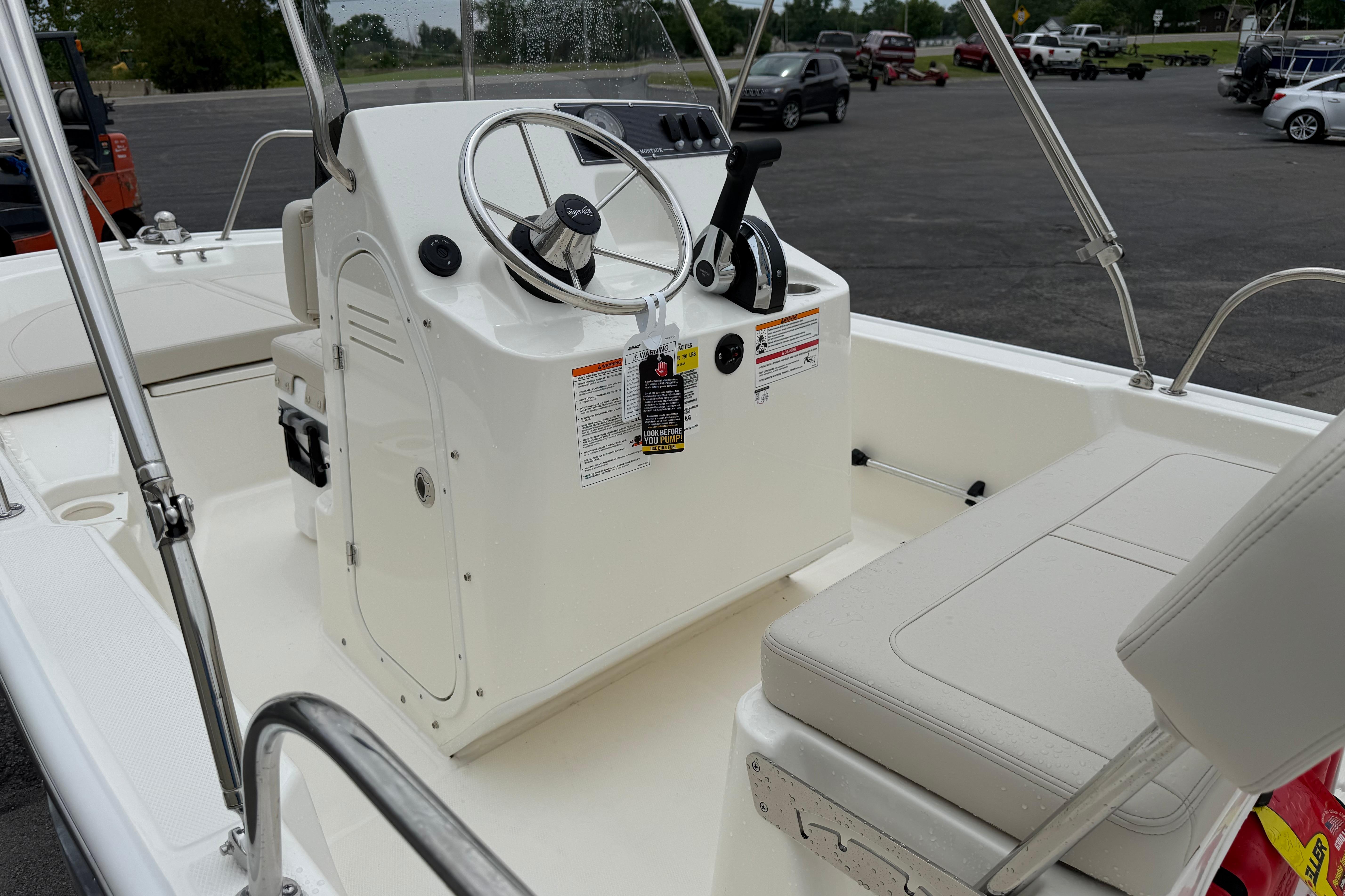 2026 Boston Whaler 150 Montauk boat interior with steering console and seating.