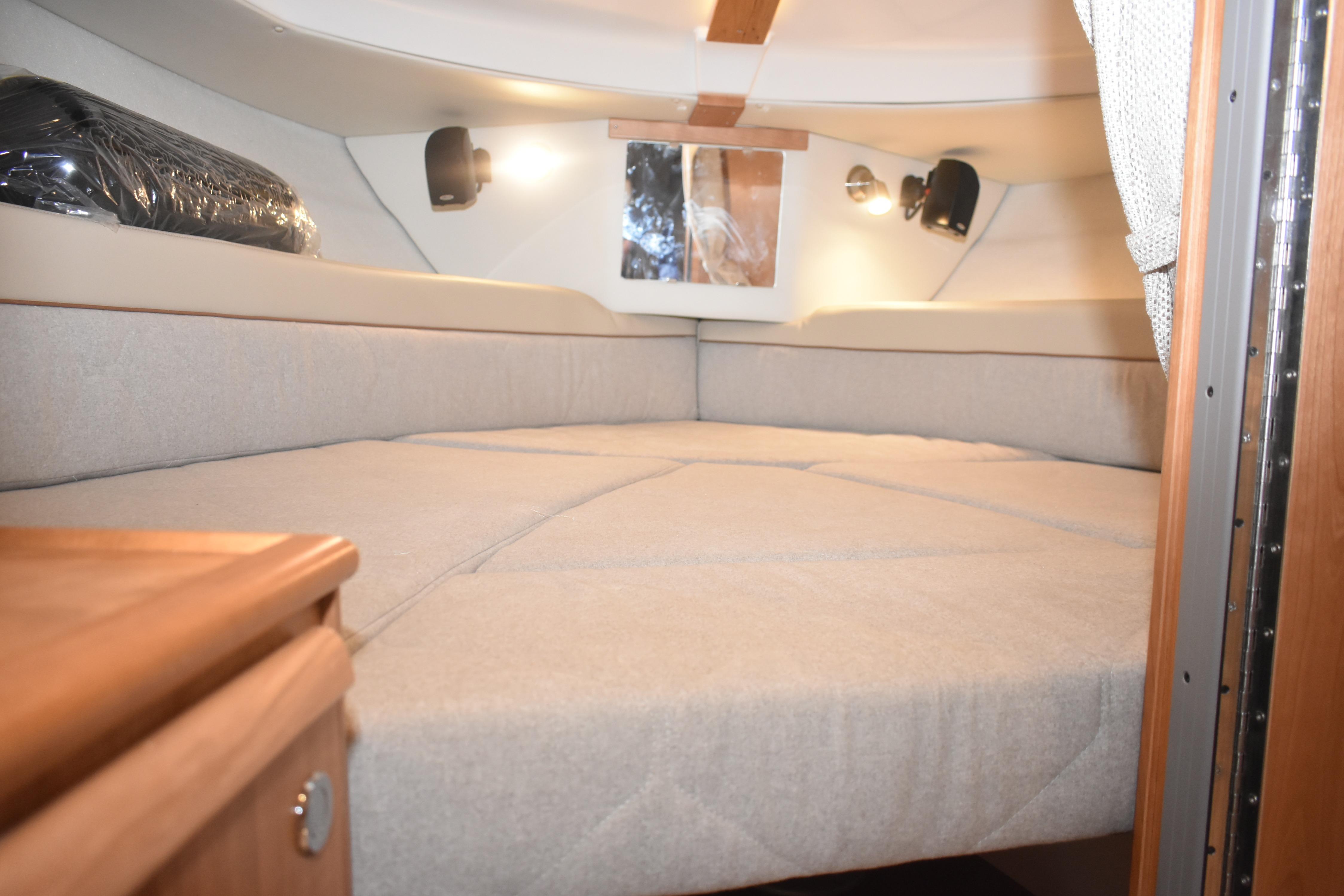 Interior cabin of 2026 Cutwater C-248 Coupe with cozy bedding and ambient lighting.