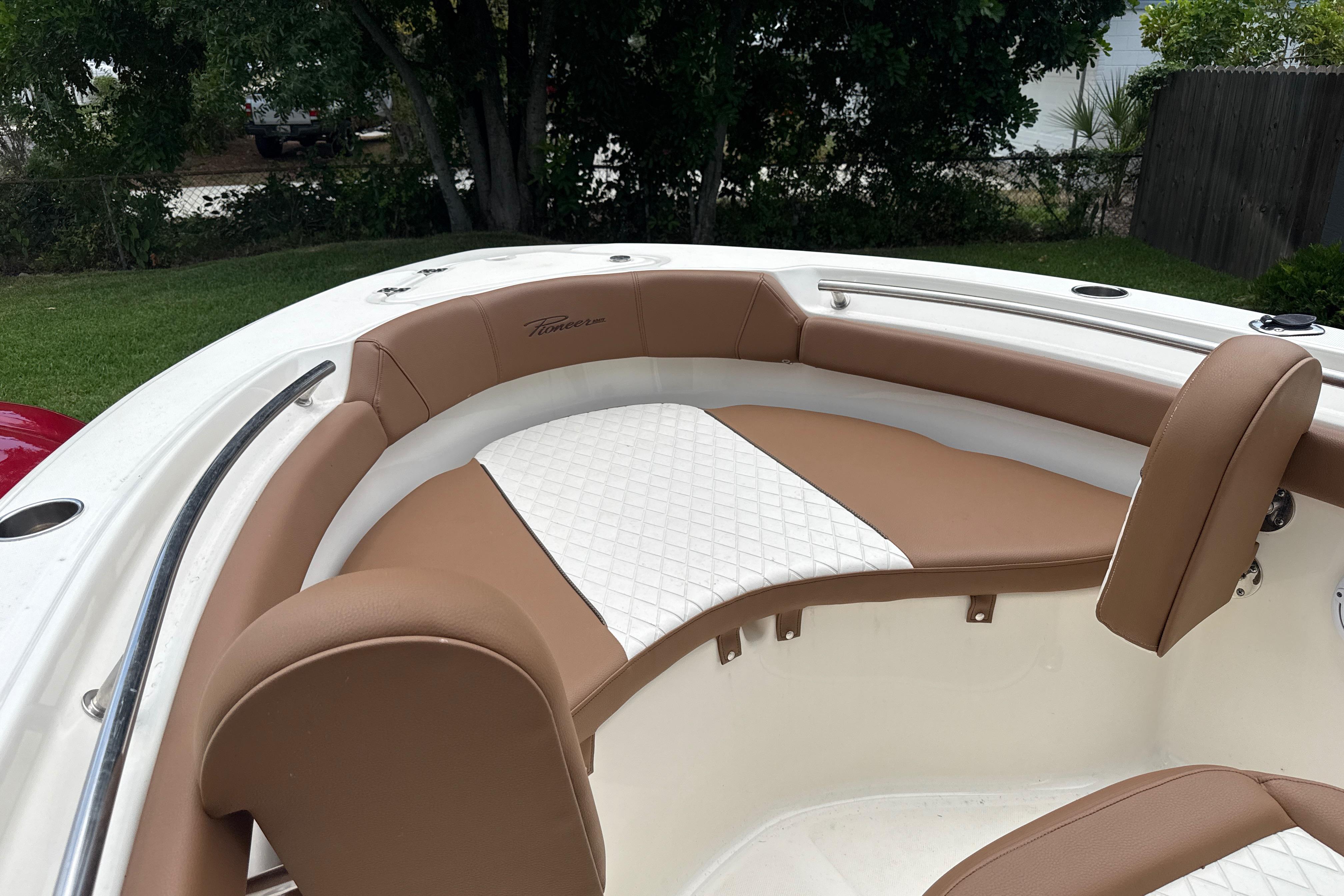 2023 Pioneer 202 Islander boat interior with tan and white cushioned seating.