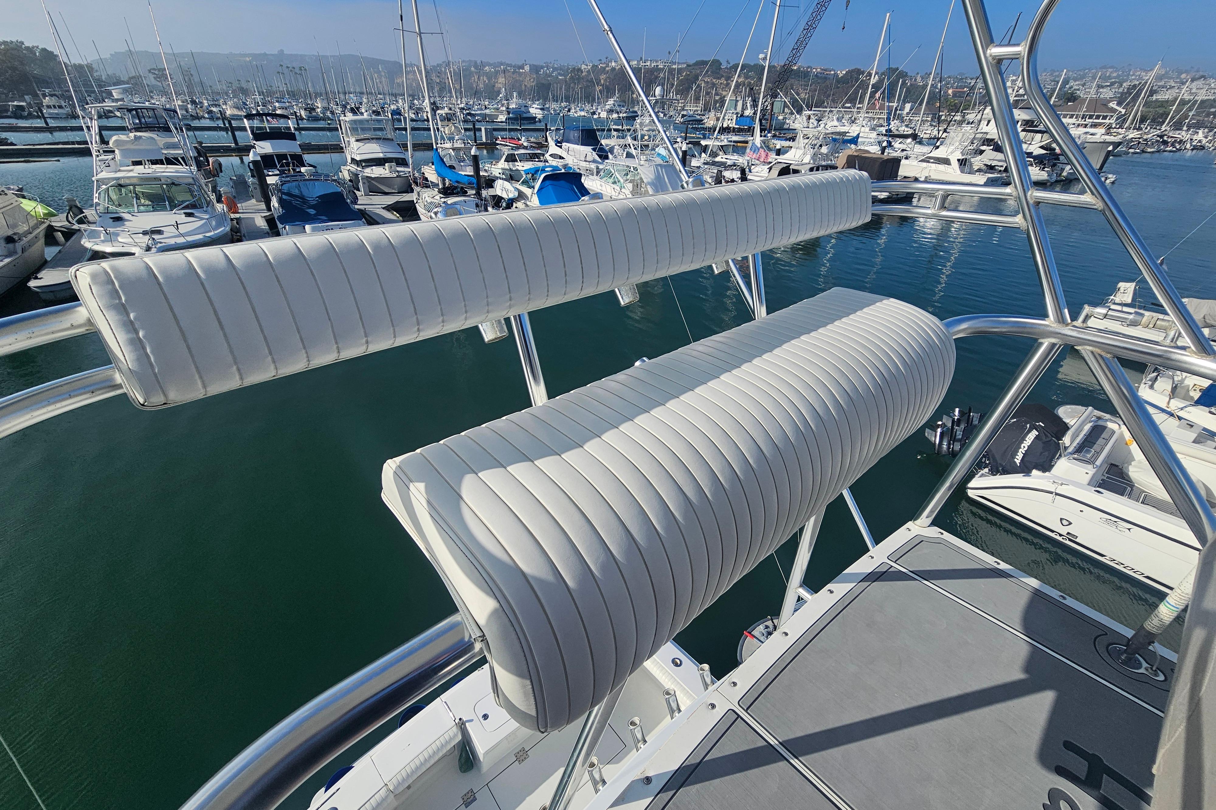 2003 Topaz 32 Express boat with white cushioned seating at a marina.