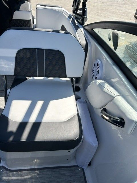 A modern boat seat with black and white upholstery and a speaker.