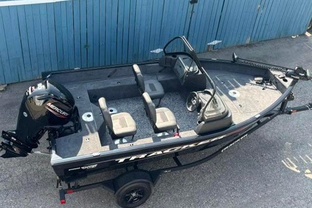 2026 Tracker Pro Guide V-16 WT fishing boat with Mercury engine, parked on trailer.
