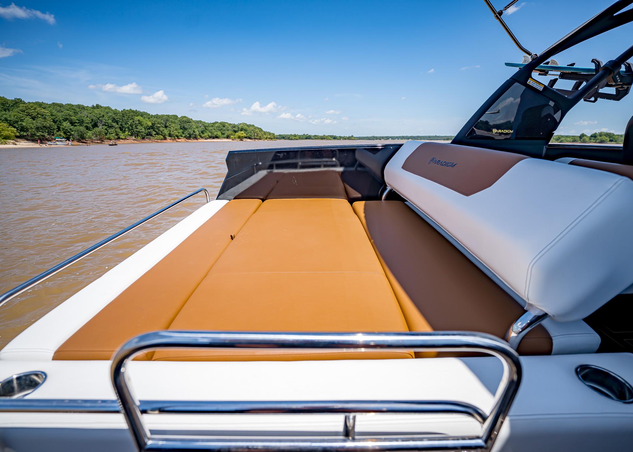 2025 Paradigm 236 boat interior with tan and white seating on a sunny day.