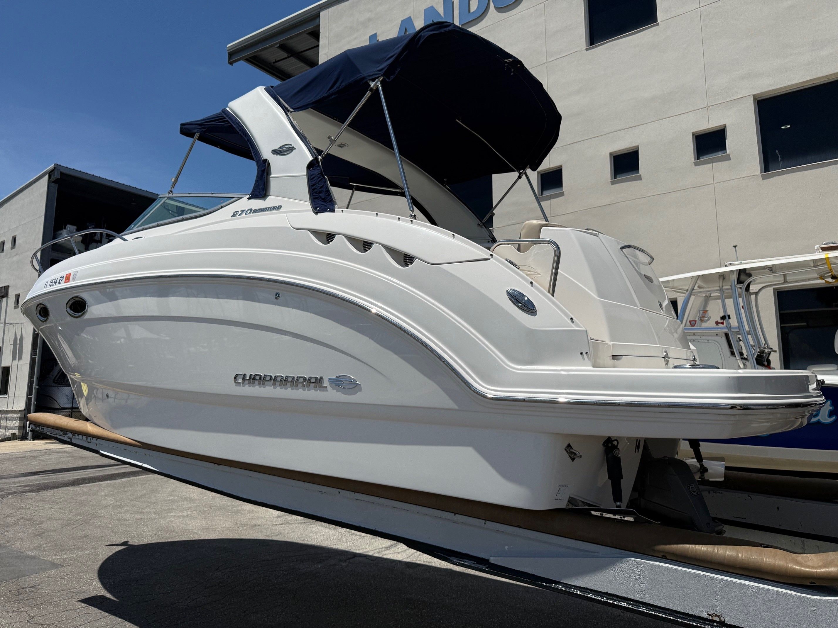 2018 Chaparral 270 Signature boat on a trailer in front of a building.